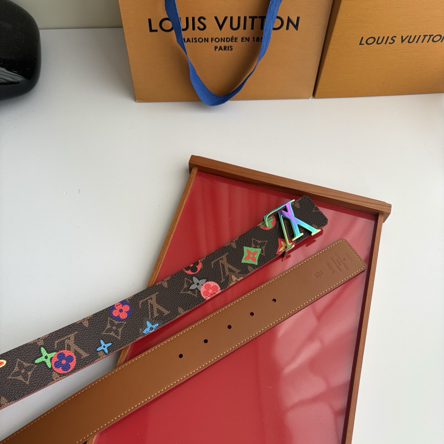 Lv当季新款，经典老花底色，叠加粉、绿、红彩色四花涂鸦印花，两面切换佩戴。正面彩色限定印花帆布；反面棕褐色光滑牛皮。宽4