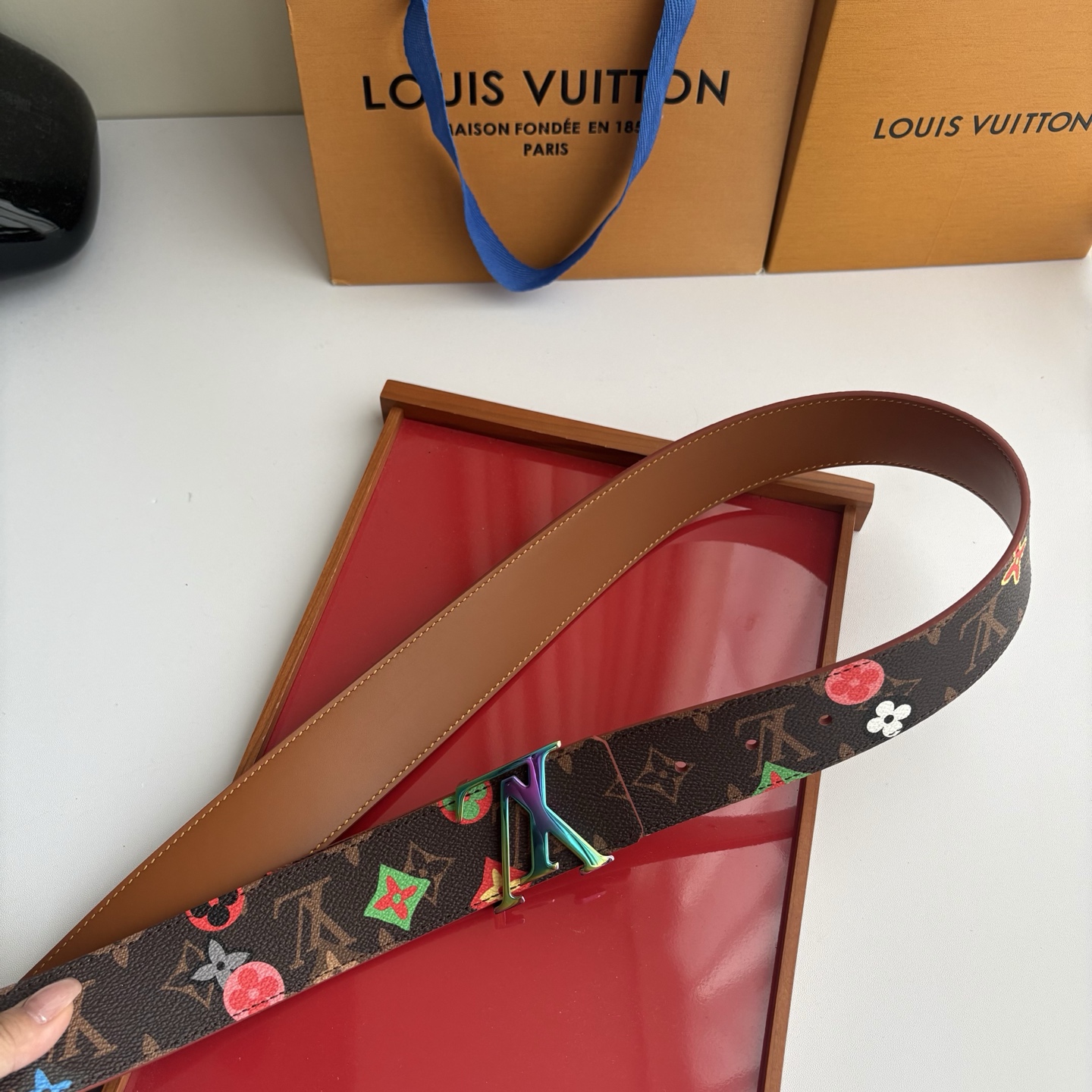 Lv当季新款，经典老花底色，叠加粉、绿、红彩色四花涂鸦印花，两面切换佩戴。正面彩色限定印花帆布；反面棕褐色光滑牛皮。宽4