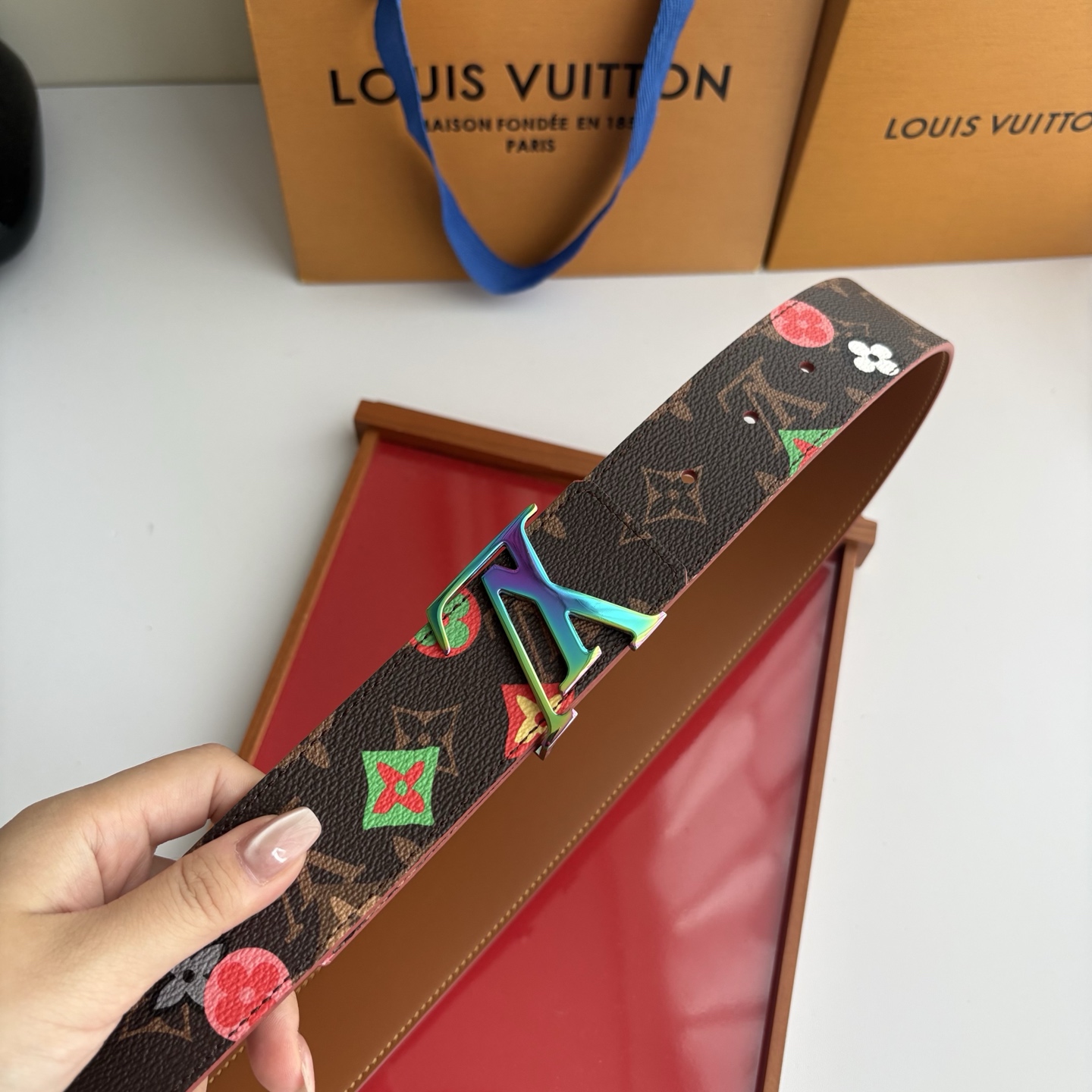 Lv当季新款，经典老花底色，叠加粉、绿、红彩色四花涂鸦印花，两面切换佩戴。正面彩色限定印花帆布；反面棕褐色光滑牛皮。宽4