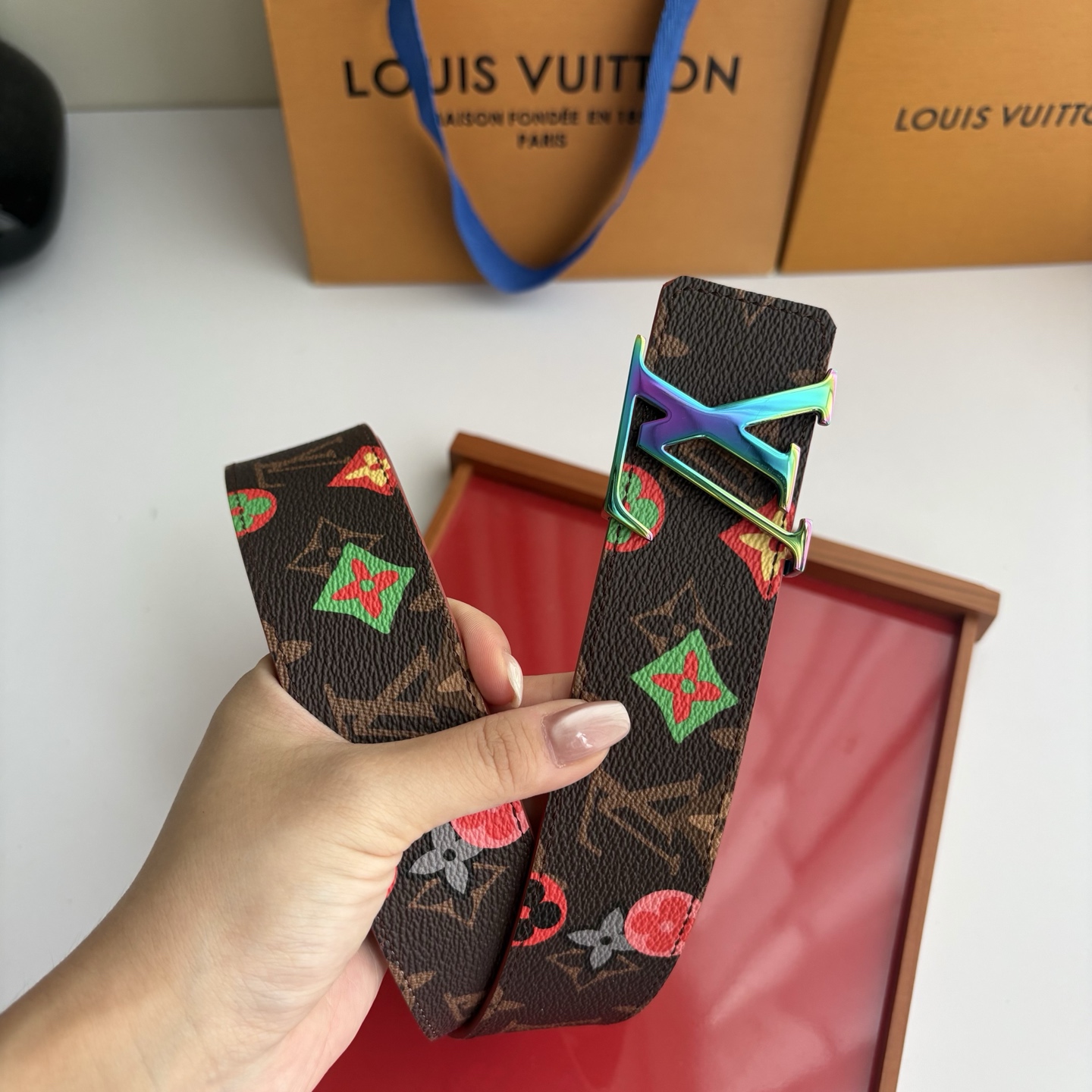 Lv当季新款，经典老花底色，叠加粉、绿、红彩色四花涂鸦印花，两面切换佩戴。正面彩色限定印花帆布；反面棕褐色光滑牛皮。宽4
