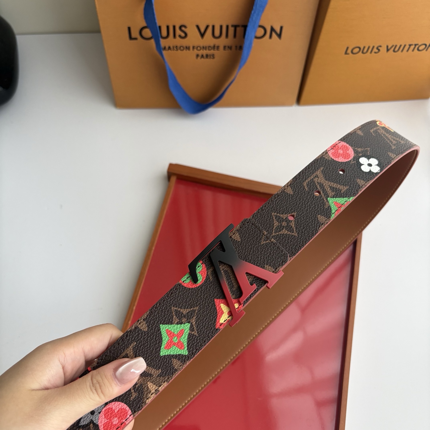 Lv当季新款，经典老花底色，叠加粉、绿、红彩色四花涂鸦印花，两面切换佩戴。正面彩色限定印花帆布；反面棕褐色光滑牛皮。宽4