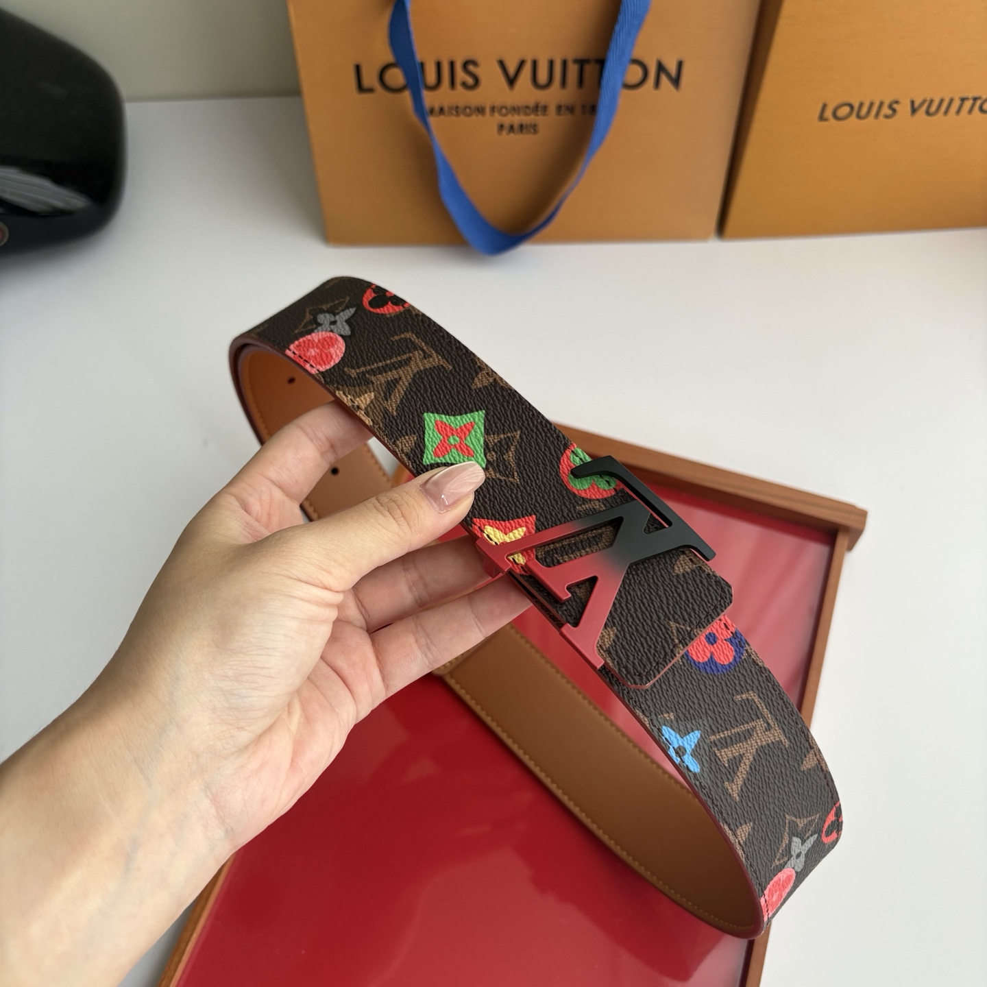 Lv当季新款，经典老花底色，叠加粉、绿、红彩色四花涂鸦印花，两面切换佩戴。正面彩色限定印花帆布；反面棕褐色光滑牛皮。宽4