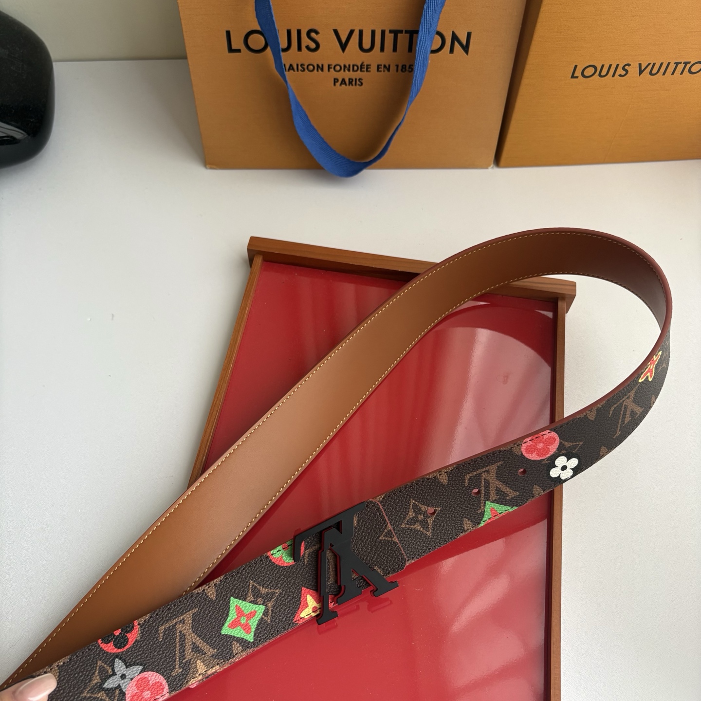 Lv当季新款，经典老花底色，叠加粉、绿、红彩色四花涂鸦印花，两面切换佩戴。正面彩色限定印花帆布；反面棕褐色光滑牛皮。宽4