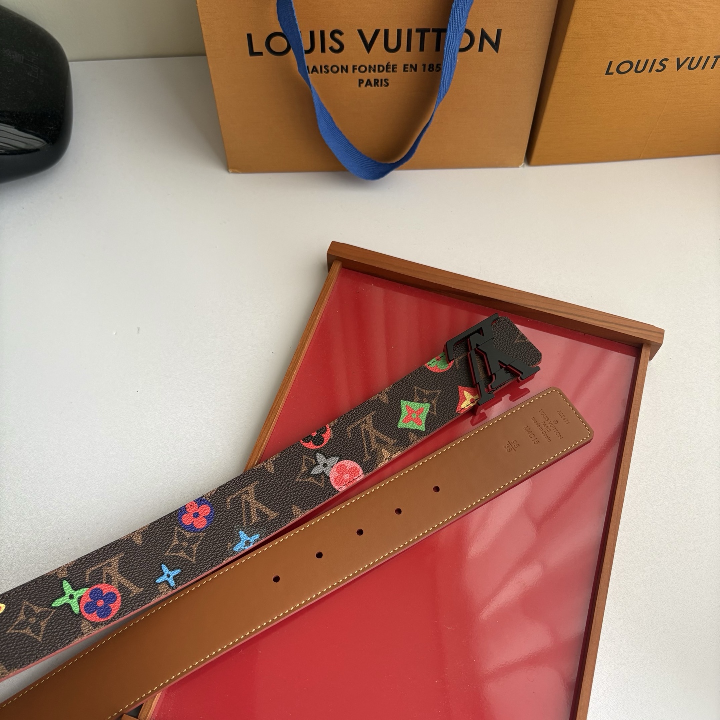 Lv当季新款，经典老花底色，叠加粉、绿、红彩色四花涂鸦印花，两面切换佩戴。正面彩色限定印花帆布；反面棕褐色光滑牛皮。宽4