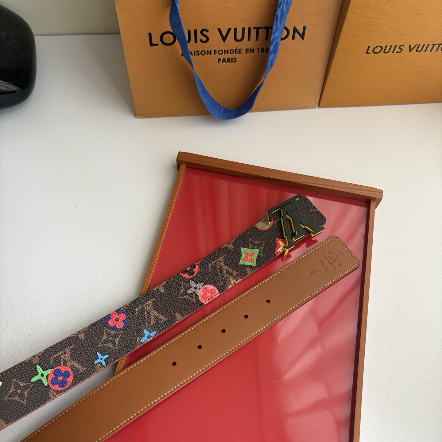 Lv当季新款，经典老花底色，叠加粉、绿、红彩色四花涂鸦印花，两面切换佩戴。正面彩色限定印花帆布；反面棕褐色光滑牛皮。宽4