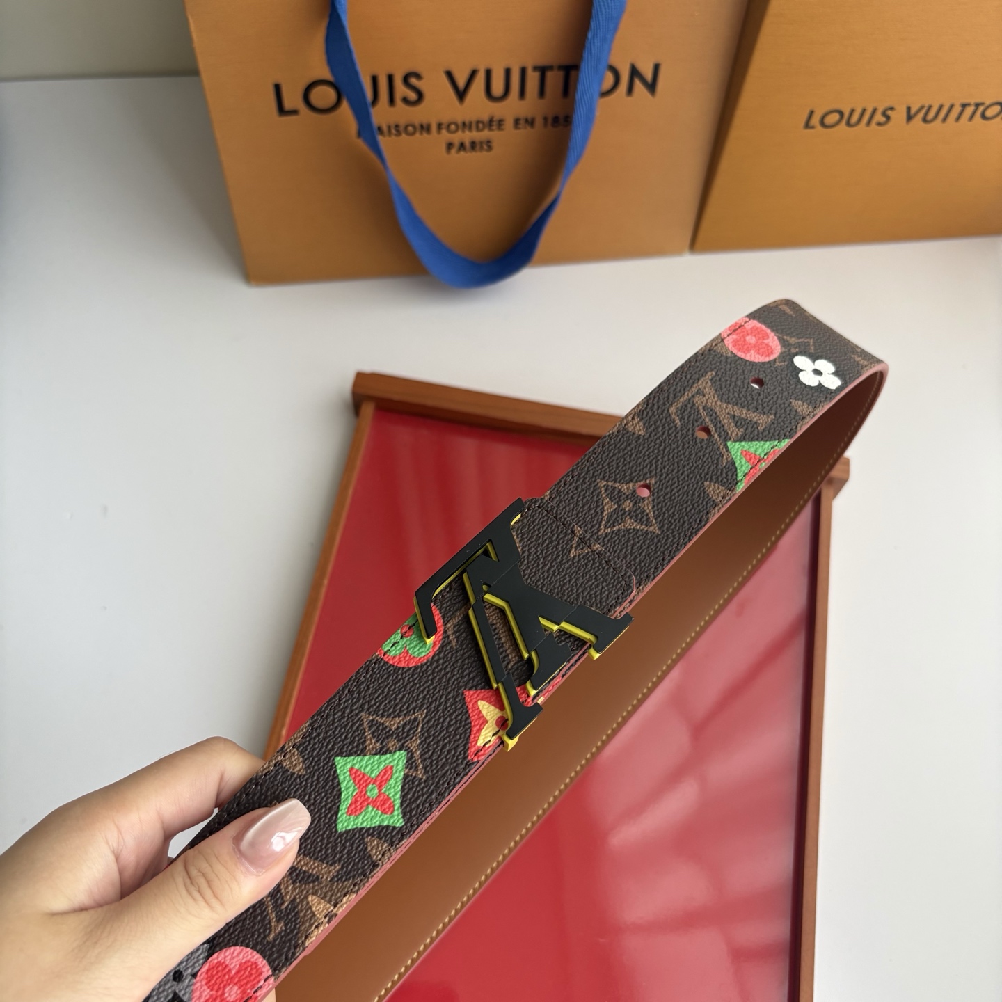 Lv当季新款，经典老花底色，叠加粉、绿、红彩色四花涂鸦印花，两面切换佩戴。正面彩色限定印花帆布；反面棕褐色光滑牛皮。宽4