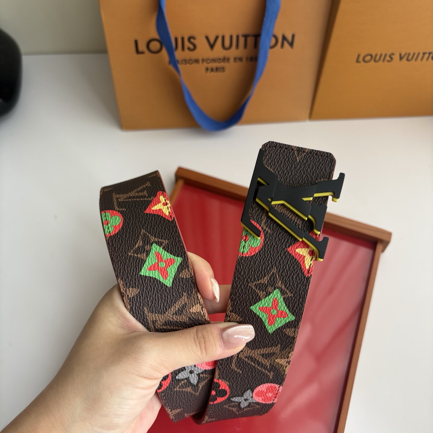 Lv当季新款，经典老花底色，叠加粉、绿、红彩色四花涂鸦印花，两面切换佩戴。正面彩色限定印花帆布；反面棕褐色光滑牛皮。宽4