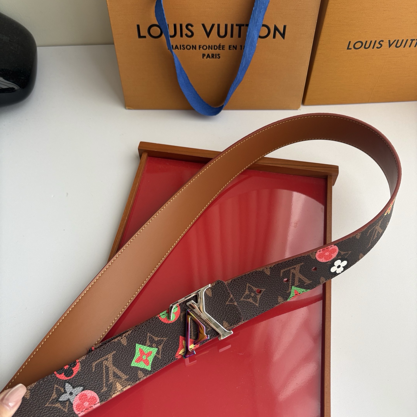 Lv当季新款，经典老花底色，叠加粉、绿、红彩色四花涂鸦印花，两面切换佩戴。正面彩色限定印花帆布；反面棕褐色光滑牛皮。宽4