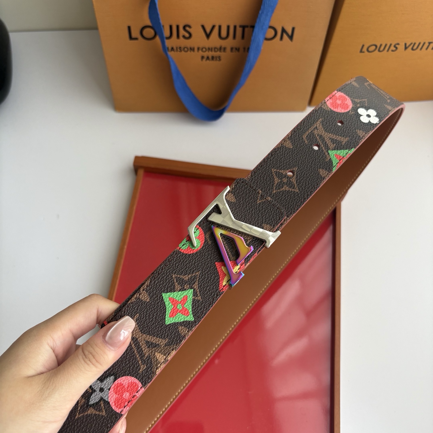 Lv当季新款，经典老花底色，叠加粉、绿、红彩色四花涂鸦印花，两面切换佩戴。正面彩色限定印花帆布；反面棕褐色光滑牛皮。宽4