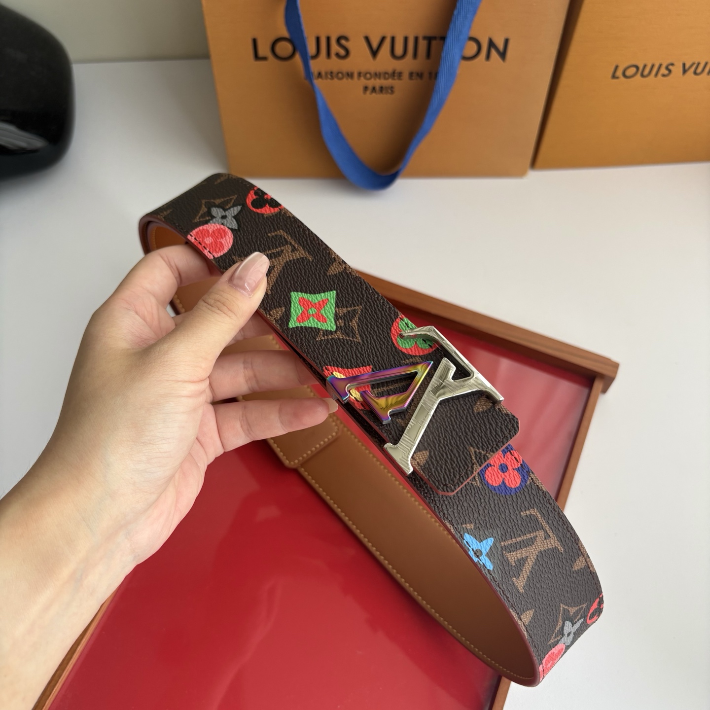 Lv当季新款，经典老花底色，叠加粉、绿、红彩色四花涂鸦印花，两面切换佩戴。正面彩色限定印花帆布；反面棕褐色光滑牛皮。宽4