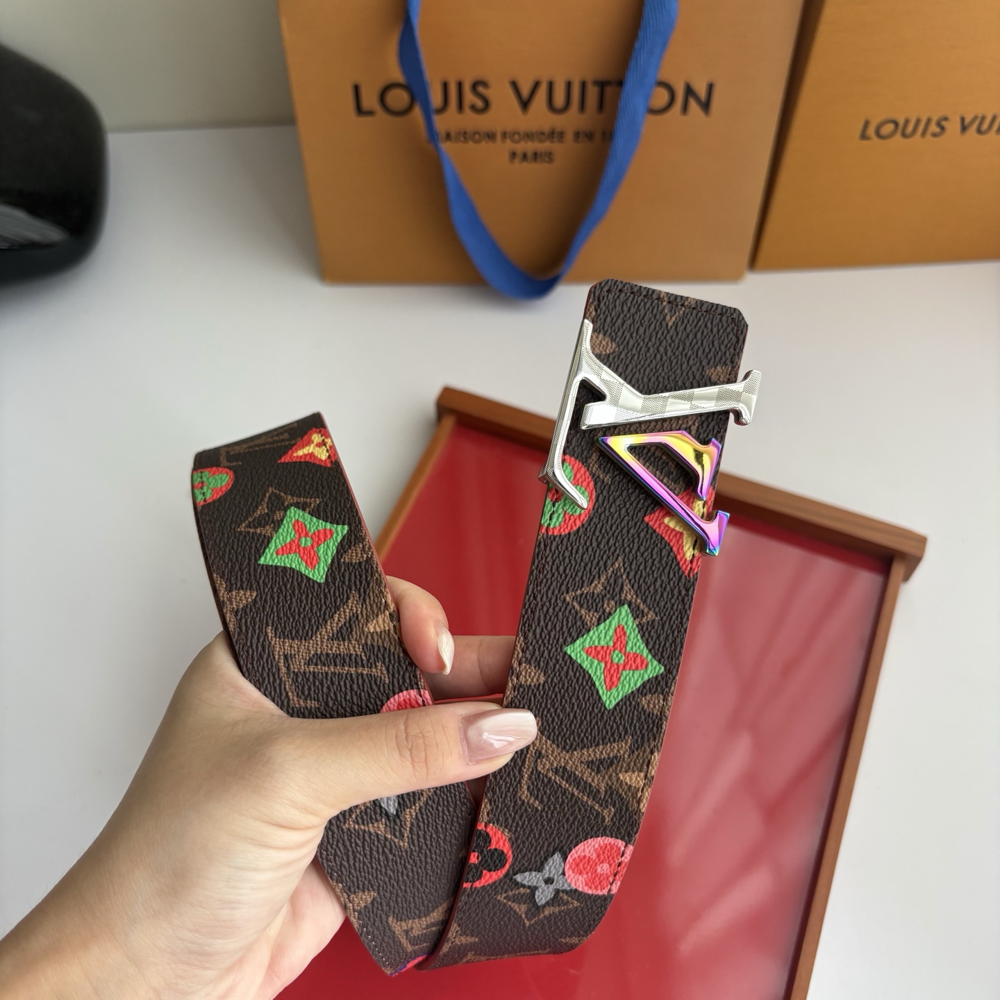 Lv当季新款，经典老花底色，叠加粉、绿、红彩色四花涂鸦印花，两面切换佩戴。正面彩色限定印花帆布；反面棕褐色光滑牛皮。宽4