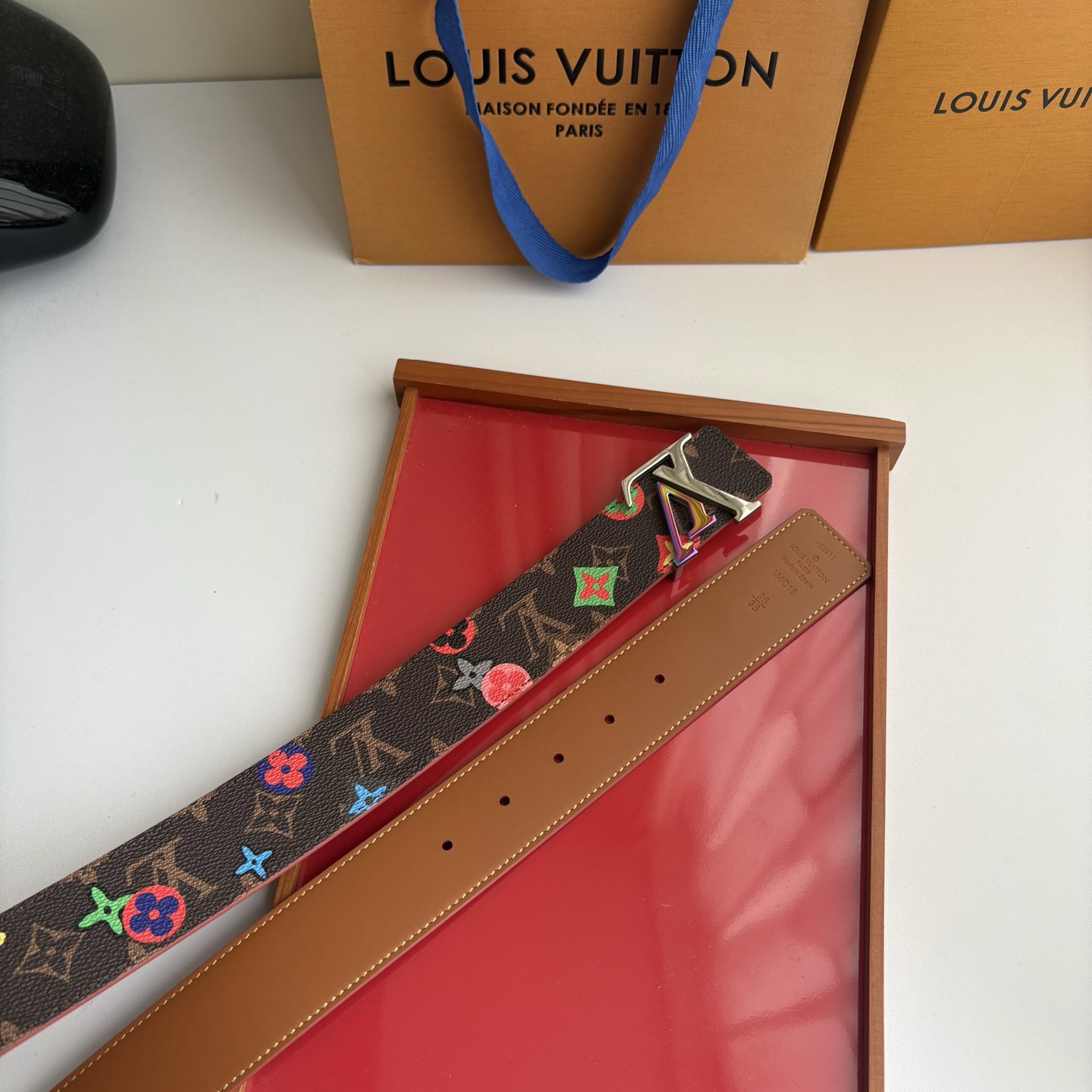 Lv当季新款，经典老花底色，叠加粉、绿、红彩色四花涂鸦印花，两面切换佩戴。正面彩色限定印花帆布；反面棕褐色光滑牛皮。宽4