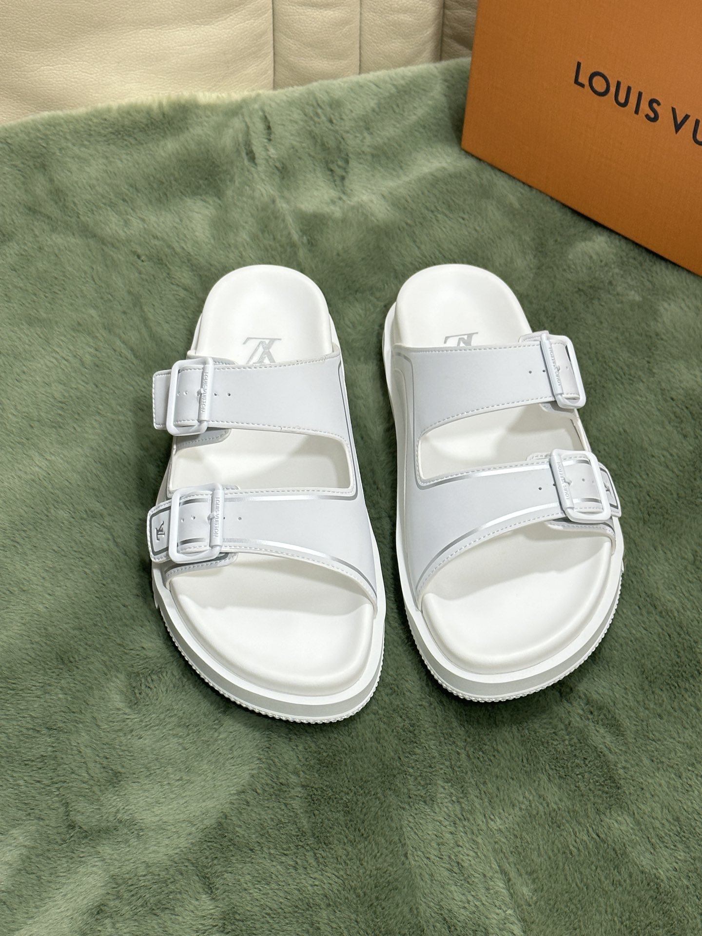 NO:271192,Size 38-45 L luxury Trainer sandals, made of white calfskin, light and comfortable. The upper is decorated with Monogram embossed. 2 adjustable straps and blue metal buckles provide a unique color splicing effect. The precise foot-fitting insole and fine-line rubber outsole are inspired by L* Trainer sneakers.,,sneakers,slippers,cowhide19860909码数38-45 L奢品Trainer 凉拖鞋,选用白色头层小牛皮材质,轻盈舒适.鞋面饰带饰有 Monogram 压纹.2 条可调节饰带搭配蓝色金属质感搭扣,带来别致的色彩拼接效果.精准贴脚的鞋垫与细纹橡胶外底灵感源自 L* Trainer 运动鞋.,,sneakers,slippers,cowhide,Men's shoes