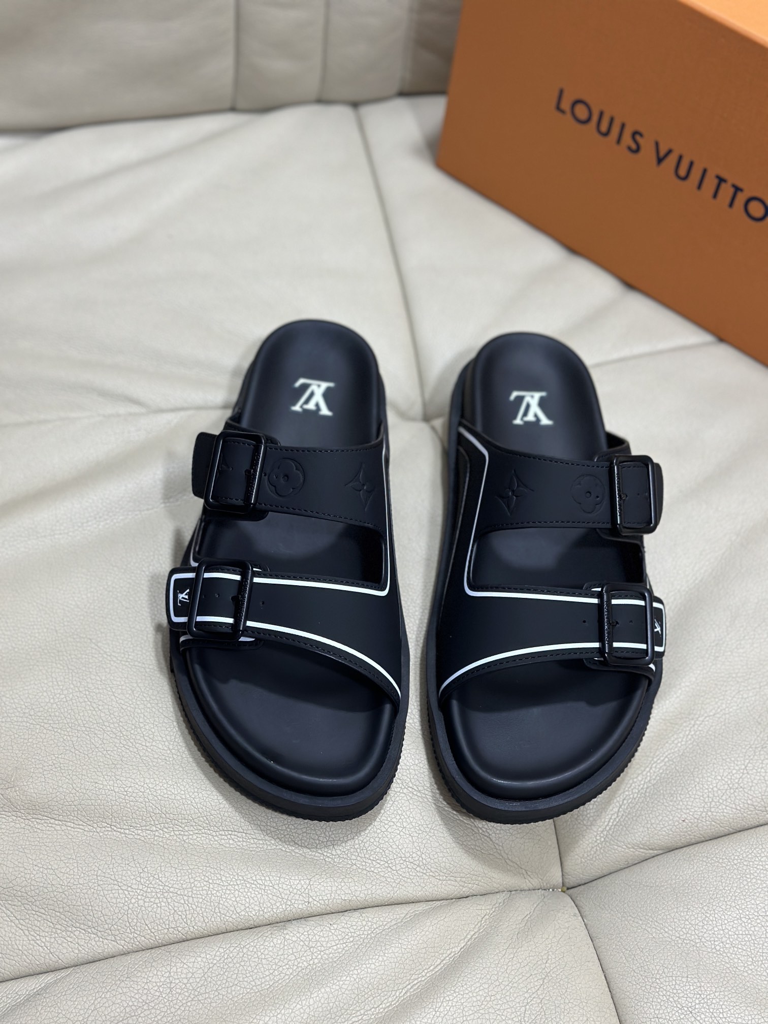 NO:559891,Size 38-45 L luxury Trainer sandals, made of black first-layer calfskin, light and comfortable. The upper straps are decorated with Monogram embossing. 2 adjustable straps with blue metal buckles bring a unique color splicing effect. The precise insole and fine-grained rubber outsole are inspired by L* Trainer sneakers., slippers, sneakers, slippers, cowhide19860909码数38-45 L奢品Trainer 凉拖鞋,选用黑色头层小牛皮材质,轻盈舒适.鞋面饰带饰有 Monogram 压纹.2 条可调节饰带搭配蓝色金属质感搭扣,带来别致的色彩拼接效果.精准贴脚的鞋垫与细纹橡胶外底灵感源自 L* Trainer 运动鞋.,拖鞋,sneakers,slippers,cowhide,Women's Shoes