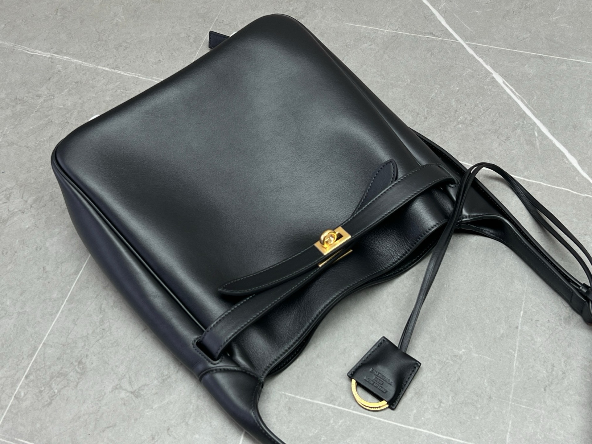 【配全套原版包装】BALENCIAGABEL AIR新品小号Hobo手袋\nBel Air黑色光滑牛皮革小号Hobo手袋，饰以做旧金色金属配件，可拆卸皮革钥匙扣，两个扣环，个主隔层 ，个内部拉链口袋\n·Nappa羊皮革复合衬里\n·尺寸：长.x高.x宽.厘米