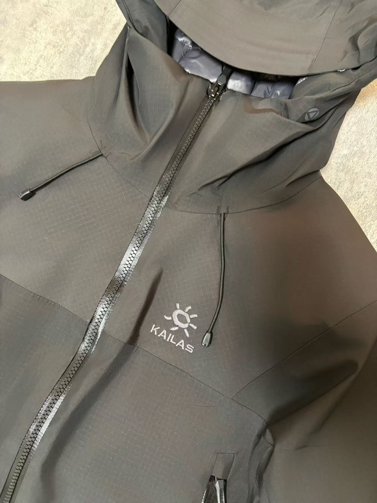💰480
顶级版本 KAILAS/阿斯本硬壳羽绒服男女同款加厚外套情侣款滑雪服登山徒步必备
外贸专供的国标90绒版本，随意对比
保暖性、防护性、舒适性等方面都超赞😬适合户外爱好者在冬季进行滑雪、徒步、登山
等活动时穿着也适用于日常的通勤和出差旅行
防风防水性强，采用FILTER-TEC 3 层硬壳面料，这种面料的防风、防水性能优异，里面接缝全压胶，能够有效抵御冬季的风雨雪天气，适合在较为恶劣的户外环境中穿着，为穿着者提供可靠的防护。
格子布耐磨性较好：硬壳面料通常具有一定的耐磨性，在户外活动中可以减少因摩擦等因素对羽绒服造成的损坏，延长其使用寿命。
羽绒填充蓬松度高：填充 700 蓬的鹅绒，蓬松度较高。在相同重量下，蓬松度越高的羽绒可以固定更多的空气，从而形成更好的隔热层，保暖性能也就越好。
绒子含量高：鹅绒的绒子含量达到 90%，绒子含量高意味着羽绒的质量好，保暖效果更出色，同时也能减少羽绒在使用过程中的结块现象，保持羽绒服的蓬松度和保暖性。
保暖科技采用石墨烯热反射：内里添加了石墨烯热反射科技，能够加强核心区的保暖。石墨烯具有良好的导热性和热反射性，可以将人体散发的热量反射回身体，提高保暖效果，在寒冷的环境中能够更好地保持身体的温暖。
风帽设计：风帽三维可调节，贴合头部，能够有效防风保暖，为头部提供额外的保护，在寒冷的天气中可以减少头部的热量散失。
袖口设计：采用魔术贴袖口，可以根据个人的需求进行调节，增强袖口的密封性，防止寒风从袖口侵入。
腋下透气拉链：配备腋下透气拉链，方便在运动过程中调节体温，避免因身体发热而产生闷热感，提高穿着的舒适性。
口袋设计：多口袋设计，方便使用者存放随身物品，如手机、钥匙、钱包等，使物品摆放井然有序，方便取用

颜色：黑色  浅云灰 

尺码：S-XXL
衣长：76 78 80 82 84
胸围：122 126 130 134 138
肩宽：49 50 51 52 54
袖长：67 68 69 70 71
s建议110斤以下
m建议110-130
L建议130-150
xl建议150—170
xxl建议170-195斤
         