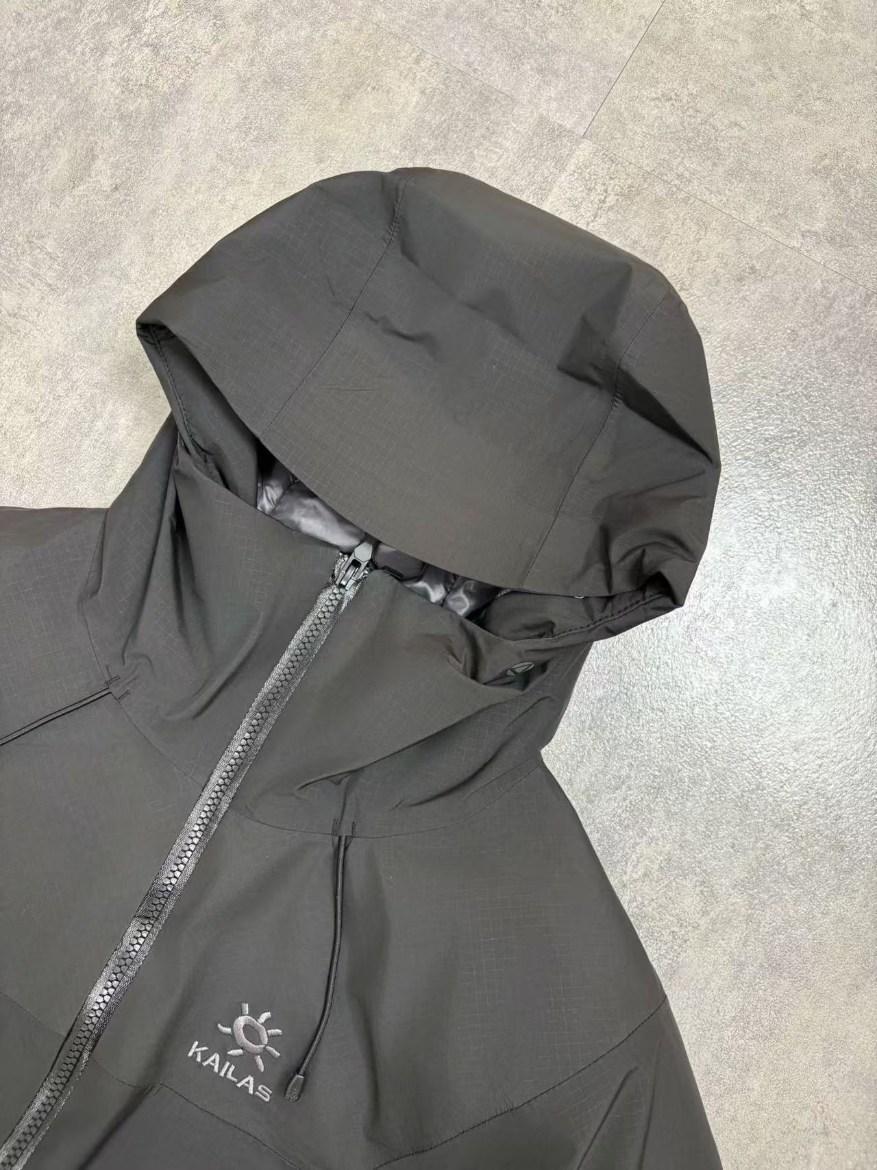 💰480
顶级版本 KAILAS/阿斯本硬壳羽绒服男女同款加厚外套情侣款滑雪服登山徒步必备
外贸专供的国标90绒版本，随意对比
保暖性、防护性、舒适性等方面都超赞😬适合户外爱好者在冬季进行滑雪、徒步、登山
等活动时穿着也适用于日常的通勤和出差旅行
防风防水性强，采用FILTER-TEC 3 层硬壳面料，这种面料的防风、防水性能优异，里面接缝全压胶，能够有效抵御冬季的风雨雪天气，适合在较为恶劣的户外环境中穿着，为穿着者提供可靠的防护。
格子布耐磨性较好：硬壳面料通常具有一定的耐磨性，在户外活动中可以减少因摩擦等因素对羽绒服造成的损坏，延长其使用寿命。
羽绒填充蓬松度高：填充 700 蓬的鹅绒，蓬松度较高。在相同重量下，蓬松度越高的羽绒可以固定更多的空气，从而形成更好的隔热层，保暖性能也就越好。
绒子含量高：鹅绒的绒子含量达到 90%，绒子含量高意味着羽绒的质量好，保暖效果更出色，同时也能减少羽绒在使用过程中的结块现象，保持羽绒服的蓬松度和保暖性。
保暖科技采用石墨烯热反射：内里添加了石墨烯热反射科技，能够加强核心区的保暖。石墨烯具有良好的导热性和热反射性，可以将人体散发的热量反射回身体，提高保暖效果，在寒冷的环境中能够更好地保持身体的温暖。
风帽设计：风帽三维可调节，贴合头部，能够有效防风保暖，为头部提供额外的保护，在寒冷的天气中可以减少头部的热量散失。
袖口设计：采用魔术贴袖口，可以根据个人的需求进行调节，增强袖口的密封性，防止寒风从袖口侵入。
腋下透气拉链：配备腋下透气拉链，方便在运动过程中调节体温，避免因身体发热而产生闷热感，提高穿着的舒适性。
口袋设计：多口袋设计，方便使用者存放随身物品，如手机、钥匙、钱包等，使物品摆放井然有序，方便取用

颜色：黑色  浅云灰 

尺码：S-XXL
衣长：76 78 80 82 84
胸围：122 126 130 134 138
肩宽：49 50 51 52 54
袖长：67 68 69 70 71
s建议110斤以下
m建议110-130
L建议130-150
xl建议150—170
xxl建议170-195斤
         