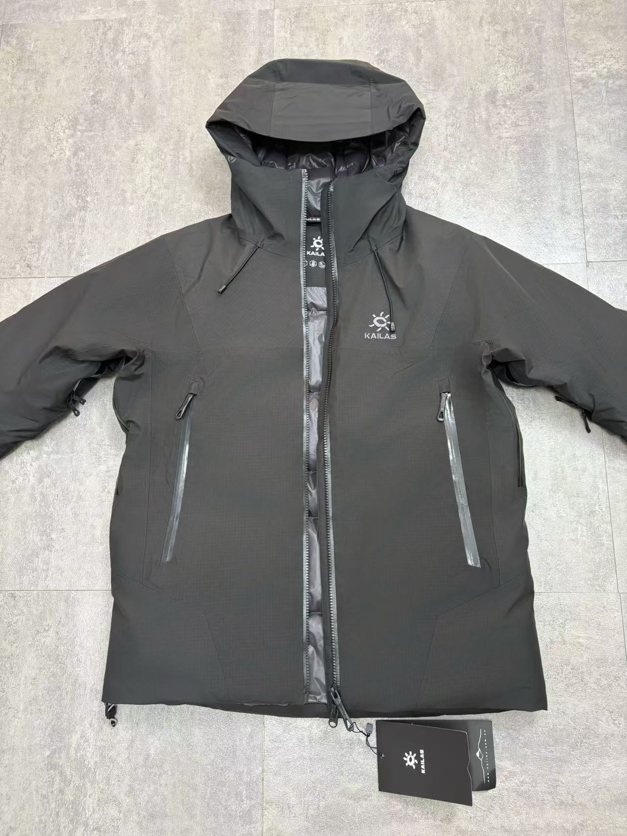 💰480
顶级版本 KAILAS/阿斯本硬壳羽绒服男女同款加厚外套情侣款滑雪服登山徒步必备
外贸专供的国标90绒版本，随意对比
保暖性、防护性、舒适性等方面都超赞😬适合户外爱好者在冬季进行滑雪、徒步、登山
等活动时穿着也适用于日常的通勤和出差旅行
防风防水性强，采用FILTER-TEC 3 层硬壳面料，这种面料的防风、防水性能优异，里面接缝全压胶，能够有效抵御冬季的风雨雪天气，适合在较为恶劣的户外环境中穿着，为穿着者提供可靠的防护。
格子布耐磨性较好：硬壳面料通常具有一定的耐磨性，在户外活动中可以减少因摩擦等因素对羽绒服造成的损坏，延长其使用寿命。
羽绒填充蓬松度高：填充 700 蓬的鹅绒，蓬松度较高。在相同重量下，蓬松度越高的羽绒可以固定更多的空气，从而形成更好的隔热层，保暖性能也就越好。
绒子含量高：鹅绒的绒子含量达到 90%，绒子含量高意味着羽绒的质量好，保暖效果更出色，同时也能减少羽绒在使用过程中的结块现象，保持羽绒服的蓬松度和保暖性。
保暖科技采用石墨烯热反射：内里添加了石墨烯热反射科技，能够加强核心区的保暖。石墨烯具有良好的导热性和热反射性，可以将人体散发的热量反射回身体，提高保暖效果，在寒冷的环境中能够更好地保持身体的温暖。
风帽设计：风帽三维可调节，贴合头部，能够有效防风保暖，为头部提供额外的保护，在寒冷的天气中可以减少头部的热量散失。
袖口设计：采用魔术贴袖口，可以根据个人的需求进行调节，增强袖口的密封性，防止寒风从袖口侵入。
腋下透气拉链：配备腋下透气拉链，方便在运动过程中调节体温，避免因身体发热而产生闷热感，提高穿着的舒适性。
口袋设计：多口袋设计，方便使用者存放随身物品，如手机、钥匙、钱包等，使物品摆放井然有序，方便取用

颜色：黑色  浅云灰 

尺码：S-XXL
衣长：76 78 80 82 84
胸围：122 126 130 134 138
肩宽：49 50 51 52 54
袖长：67 68 69 70 71
s建议110斤以下
m建议110-130
L建议130-150
xl建议150—170
xxl建议170-195斤
         