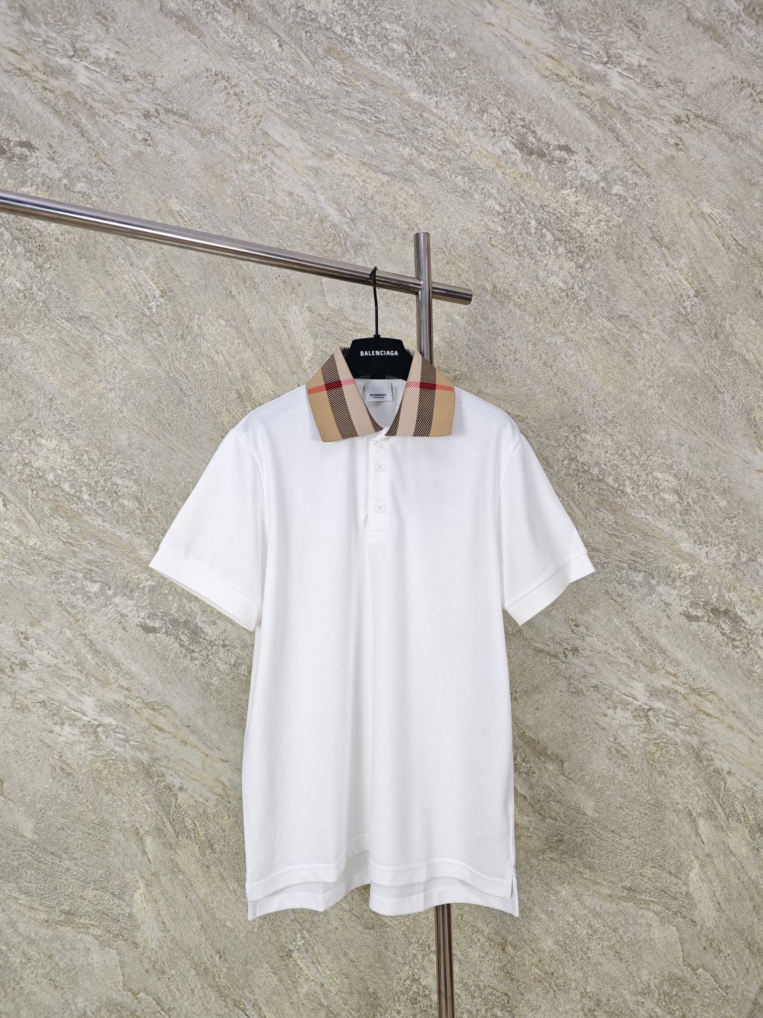 NO:824464,Top quality BURBERRY cotton polo shirt. Made of cotton pique mesh fabric, it has good breathability. The pique mesh structure gives it a unique texture and enhances the texture. It absorbs moisture and perspiration to keep it comfortable to wear. The classic POLO shirt style with craftsmanship and details plus BUR's classic plaid jacquard collar highlights the brand recognition.  One-to-one customized button placket, the placket is made of double-layer fabric to increase durability. The shoulders are made of double-needle hemming technology, which is better fixed and not easy to fall off. The cuffs are made of elastic thread knitting, and the threads of double-needle machine knitting are clear and elastic. They fit the arms better and are not easy to deform. The hem is slit on both sides and has a classic design of long in the front and short in the back, which improves sports comfort and enhances the shape of the clothing. The entire hem is sewn with double needles to ensure firmness. SIZES M L  XL,Burberry-clothing,burberry,19860909顶级品质 BURBERRY棉质POLO衫 面料棉质珠地网眼布面料打造,透气性好,珠地网眼结构赋予了它独特的纹理,提升质感.吸湿排汗,保持穿着舒适 工艺和细节经典的POLO衫款式加上BUR经典的格纹提花领,凸显品牌辨识度. 一比一定制纽扣开襟,门襟使用双层布料,增加耐用性.肩部采用双针包边工艺,更好的固定,不易脱线.袖口采用弹性螺纹针织,双针机编织的螺纹,螺纹清晰,弹性十足 更好的贴合手臂,不易变形.下摆两侧开叉,做了前长后短的经典设计,提升了运动舒适度,增强服装版型,下摆整体使用双针缝制确保牢固. SIZES M L XL,博柏利-服装,burberry,,Women's clothing