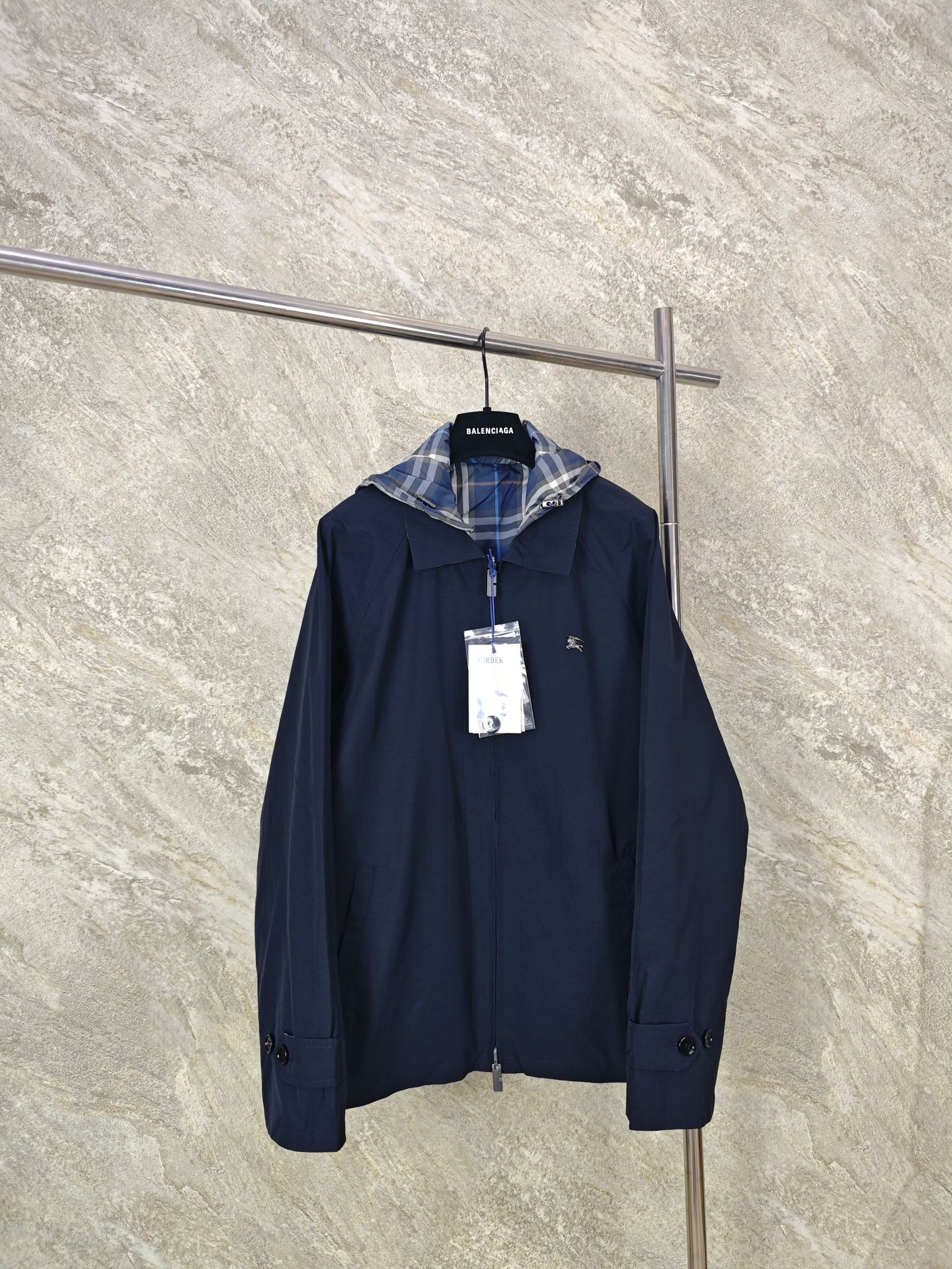 NO:824367,Top quality BBR Burberry reversible hooded jacket. Front fabric selection. Made of high-count lightweight cotton canvas.  , after pre-shrinking and softening, the canvas fabric has got rid of the traditional stiffness and has excellent breathability properties. At the same time, the fabric has a tight structure and strong wrinkle resistance. It is not easy to wrinkle and deform in daily wear. It can still maintain a crisp shape after multiple washings and has full durability. The appearance shows a matte and delicate texture, with a high-end retro texture. The pure black background is low-key and elegant, and is versatile and not picky. On the other hand, fabric selection  The blue plaid fabric made of polyester fiber has a tight structure, strong wear resistance and tear resistance. It is not easy to snag or pill when worn in daily wear, and always remains neat and crisp. After lightweight treatment, the upper body is light and weight-free, and has good breathability. The war horse logo on the chest is made of three-dimensional die-casting technology, with a delicate metallic luster, a three-dimensional and full shape, and the edges are polished smooth, showing a high-end texture. Size: 46485052, Burberry-clothing, jackets  & coats,hats,19860909顶级品质 BBR博柏利双面穿连帽夹克  正面面料选择 甄选高支轻盈棉质帆布打造 ,经过预缩与柔化处理,帆布面料摆脱了传统硬挺感,其自带优秀的透气属性,同时面料结构紧密、抗皱性强,日常穿着不易起皱变形,多次洗涤仍能保持挺括版型,耐穿度拉满.外表呈现哑光细腻的肌理,自带高级的复古质感,纯黑底色低调大气,百搭不挑风格. 另一面面料选择 选用聚酯纤维打造而成的蓝色格纹面料,其结构紧密,耐磨性、抗撕裂性强,日常穿着不易勾丝、起球,始终保持利落挺括.经过轻量化处理之后,上身轻盈无负重,同时具备良好的透气性. 胸口处战马徽标采用立体压铸工艺打造,金属光泽细腻,造型立体饱满,边缘经打磨光滑,呈现高级质感. Size:46485052,博柏利-服装,jackets & coats,hats,,Women's clothing