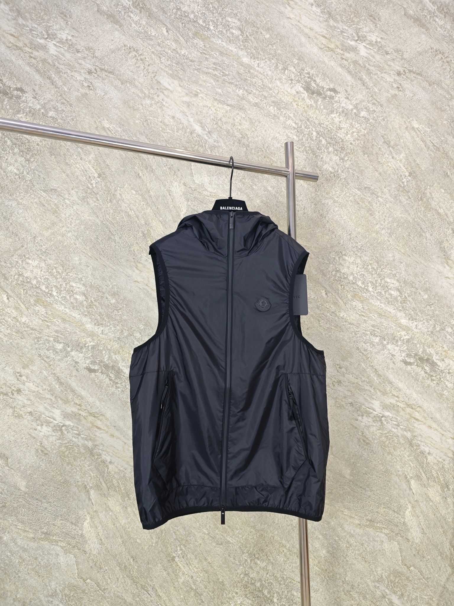 NO:824358,Top quality MONCLER hooded reflective printed vest. Fabric selection: Made of 20D ultra-light nylon fabric, treated with anti-fouling, waterproof and tear-resistant composite technology. The surface presents a unique silk luster touch. It is paired with a nylon lining to form a 0.7KG ultra-lightweight protective layer, taking into account breathability and temperature locking.  The reflective letter mark and LOGO are firmly attached to the hood and back through heat pressing to form a washable and friction-resistant reflective layer. The pattern is fine and the reflective effect is uniform, and the external light source is reflected back to the direction of the light source to form a cone-shaped beam, thereby achieving a high-brightness reflective effect.  The cap circumference, cuffs and hem are all closed with elastic hemmed webbing. Through precise temperature control and high-frequency lamination, the webbing and fabric edges form a molecular-level fusion, making it a seamless fit and improving durability and aesthetics. SIZE: 1 2 3 4, Moncler, hats,19860909顶级品质 MONCLER连帽反光印花马甲 面料选择: 采用20D超轻尼龙面料制成,经防污防水抗撕裂复合工艺处理,表面呈现独特的丝绸光泽触感,搭配尼龙衬里,形成0.7KG超轻量防护层,兼顾透气性和温度锁存. 通过热压将反光字母标和LOGO牢固附着于兜帽以及后背处,形成耐洗,耐摩擦的反光层.图案精细且反光效果均匀,将外来光源反射回光源方向,形成锥形光束,从而实现高亮度反光效果. 帽围,袖口和下摆均采用弹力包边织带收口,通过精准温控高频压合,使织带和面料边缘形成分子级融合,使其无缝贴合,耐用性和美观性都得到了提升. SIZE:1 2 3 4,蒙口-服装,Moncler,hats,,Women's clothing