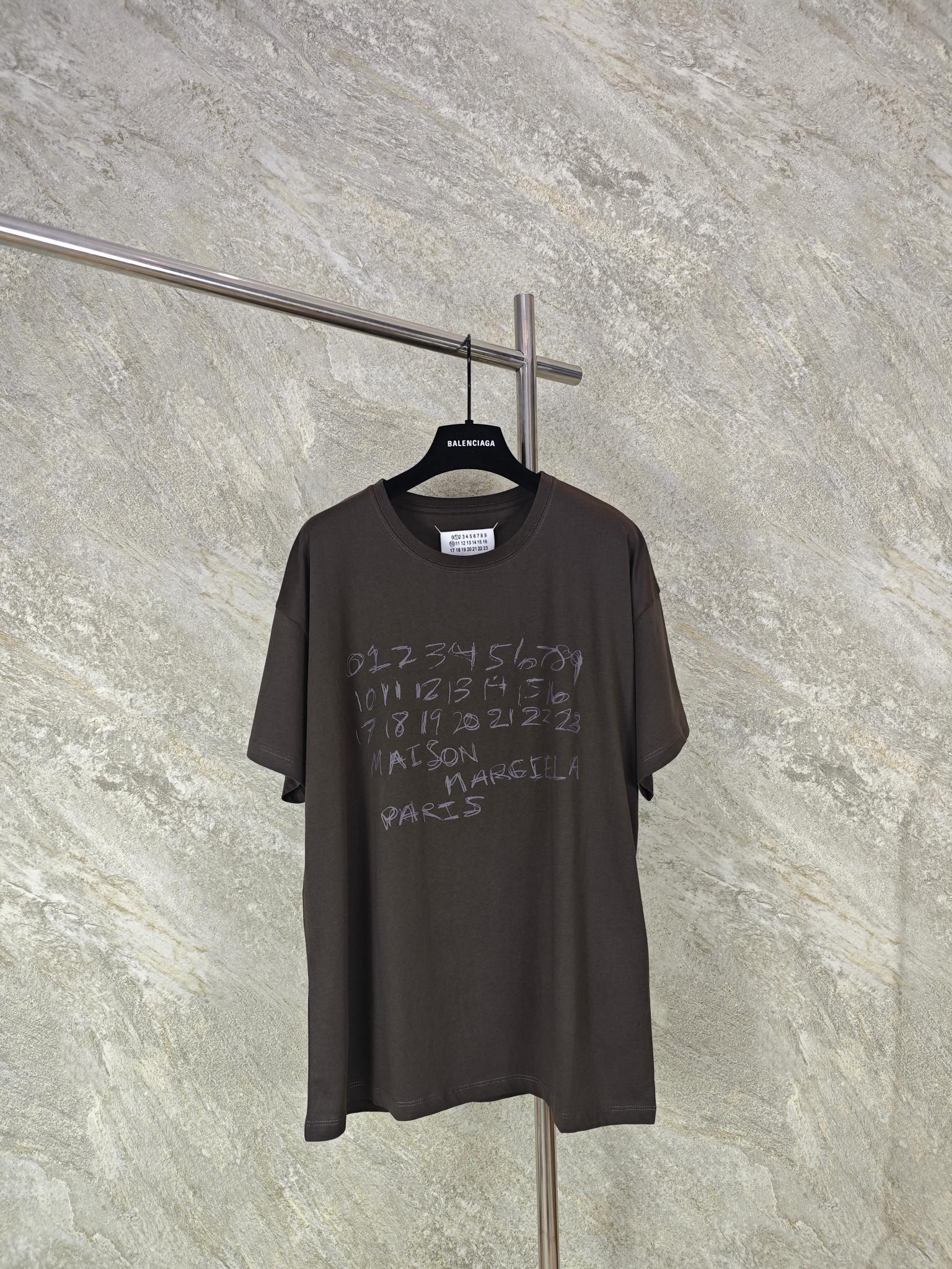 NO:824191,Top quality [ready in stock] Mm6 Margiela digital graffiti short-sleeve size S M L Customized washed faded cotton plain brocade, soft and delicate, comfortable and close to the skin. It uses dark gray as the base color to give the color a unique layer and depth. It is guided by a string of mysterious numbers to strengthen the brand identity. It complements the iconic four-corner stitching on the back panel and tells the brand's exploration and reshaping of the boundaries of fashion. The graffiti is developed in the deep gray and is printed with glue.  The chest printing has been modified three times with the film screen. The pattern is printed on the fabric using glue liquid paint. The fabric is baked to fix the printed pattern. Each piece is hand-sewn by the master to ensure the accuracy of position and spacing. The hand-stitching process can better reflect the craftsman's exquisite skills and control of details. Men's clothing, masion margiela, masion margiela, T-shirt,19860909顶级品质【现货】Mm6 马吉拉数字涂鸦短袖 size S M L 定制凝萃洗褪棉平纹锦 柔软细腻 舒适贴肤 以深邃灰为底色 赋予色彩独特的层次与深度 以一串神秘数字为引 强化品牌标识 与后幅标志性的四角缝线相得益彰 诉说着品牌对时尚边界的探索与重塑 涂鸦在深邃灰色中显影.采用胶浆印花 胸前印花经过三次菲林网板修改 使用胶浆液体涂料在织物上打印图案 烘烤织物以固定印刷图案.每件皆由师傅纯手工缝标 可以确保位置和间距的准确率 手缝工艺更能体现匠人的精湛技艺和对细节的把控.,男装,masion margiela,masion margiela,T-shirt,,Women's clothing