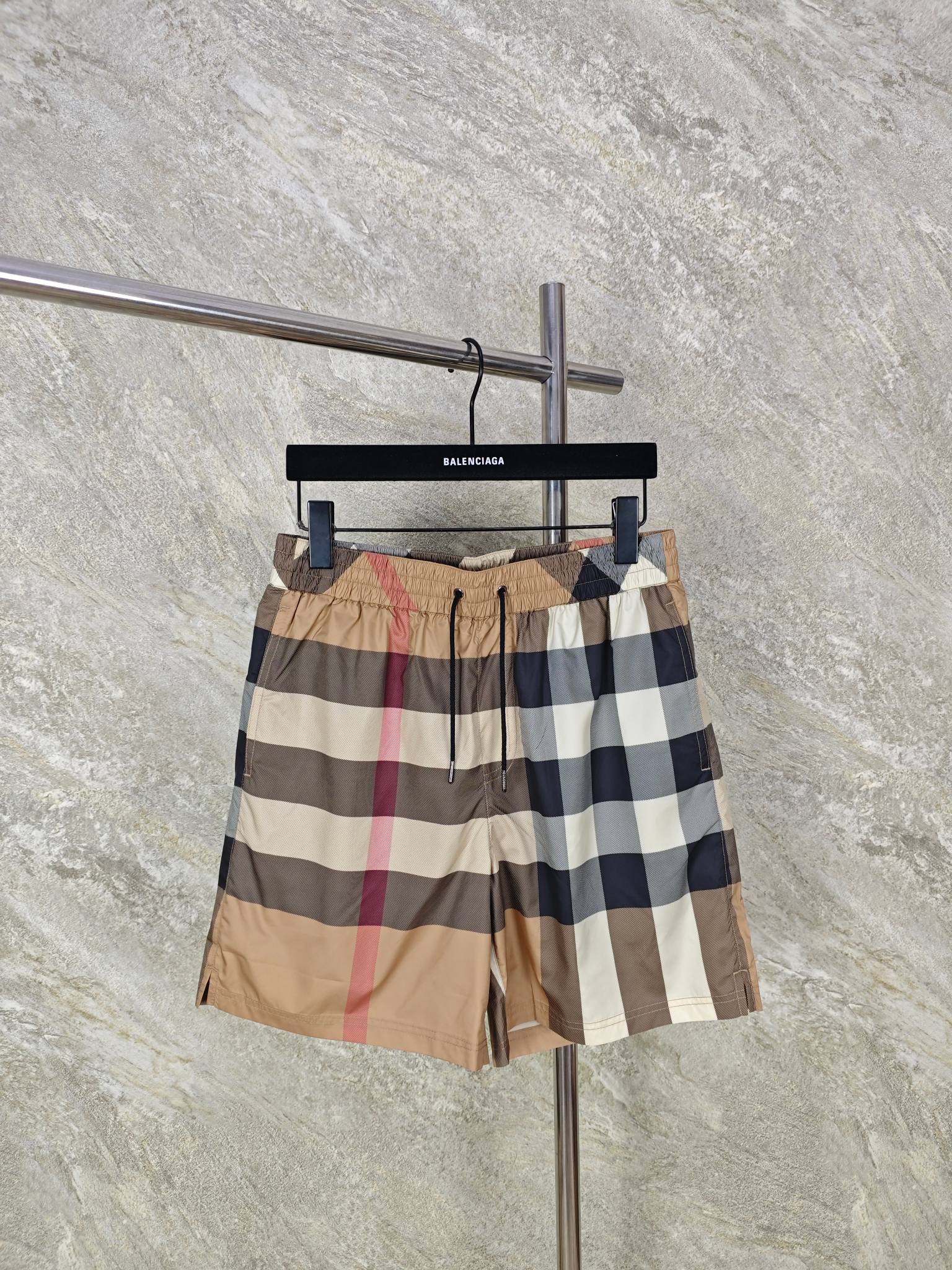 NO:824030,Top quality Bur classic plaid board shorts  It is made of high-density polyester fiber fabric, which has been treated with a shaping process to say goodbye to the pain points of being easy to wrinkle and deform. At the same time, polyester fiber has excellent moisture absorption and moisture conduction properties. The micro-breathable structure on the surface can quickly discharge moisture from the body surface. After sweating during exercise, it can be dry and non-sticky in a short time, saying goodbye to the embarrassment of hot and sticky legs. Its wear-resistant and tear-resistant properties are also relatively excellent. It is not easy to pill or snag after daily friction and washing many times. It does not collapse for a long time and can maintain a neat fit for a long time.  Size:SMLXL,Burberry-clothing,burberry,19860909顶级品质 Bur经典格纹沙滩裤 采用高密聚酯纤维面料,经过定型工艺处理之后,告别易皱、易变形的痛点,同时聚酯纤维自带优异的吸湿导湿属性,表面的微透气结构能快速排出体表湿气,运动出汗后,短时间即可干爽不黏腻,告别闷热黏腿的尴尬.其耐磨抗撕裂性能也相对优异,日常摩擦、水洗多次后依旧不易起球、不易勾丝,久穿不塌,能长久保持利落版型. Size:SMLXL,博柏利-服装,burberry,,Women's clothing