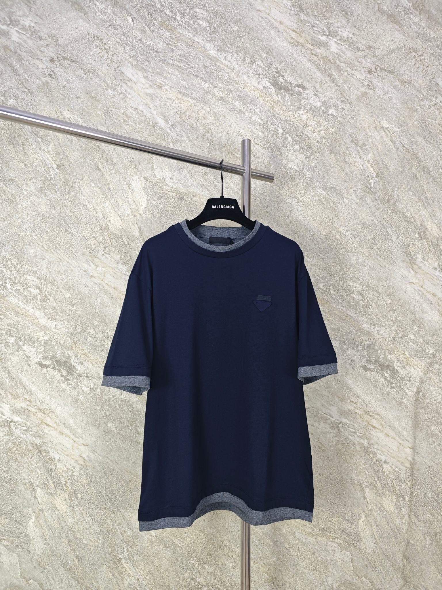 NO:865769,Top-quality PRADA fake two-piece triangular logo short-sleeves. High-count long-staple combed cotton fabric is selected as the main material of the body. The cotton fiber has excellent breathability and perspiration performance, and can quickly export hot and humid moisture from the body surface. The soft and waxy drape fabric property is not tight on the upper body and does not stick to the skin. At the same time, the surface has been treated with pre-shrunk sanding process, making the cloth surface smooth and delicate without rough yarn grains, showing a low-saturated navy blue tone.  Size:SMLXL,Prada-clothing,prada,prada,T-shirt,19860909顶级品质 PRADA假两件三角标短袖 甄选高支长绒精梳棉面料作为衣身主料. 棉纤维透气排汗性能优,能快速导出体表闷热湿气,软糯垂坠的面料属性上身不紧绷、不贴肤.同时表面经过预缩磨毛工艺处理,布面平整细腻无粗糙纱粒,呈现低饱和藏青色调. Size:SMLXL,普拉达-服装,prada,prada,T-shirt,,Women's clothing