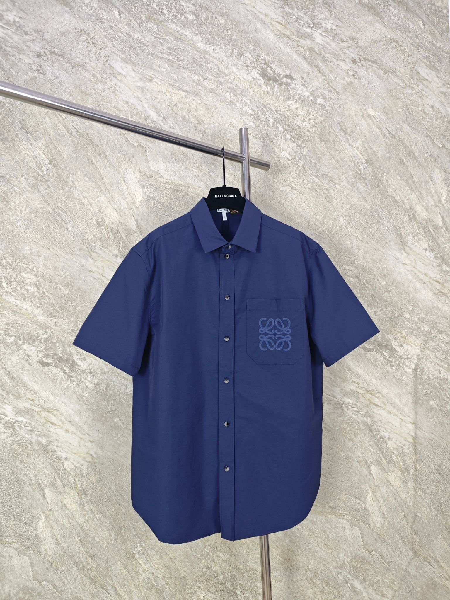 NO:885813,Top-quality LOEWE patch-pocket embroidered short-sleeved shirt is made of 83% cotton + 17% nylon blended poplin. The high content of cotton fiber gives the fabric a natural skin-friendly feel, is breathable and moisture-absorbing, makes it dry and non-sweaty when worn next to the skin, and has a soft and skin-friendly touch. The addition of nylon fiber greatly improves the strength and wear resistance of the fabric. It is not easy to snag or fluff after long-term wear. It has micro-elastic properties and is free of movement. Size: 46 48 50  52,Loewe-clothing,loewe,loewe,shirts,T-shirt,19860909顶级品质 LOEWE贴袋绣花短袖衬衫 甄选83棉+17锦纶混纺府绸而成.高含量棉纤维赋予面料天然亲肤感,透气吸湿,贴肤穿着干爽不闷汗,自带柔和亲肤触感.锦纶纤维的加持大幅提升面料强度与耐磨性,久穿不易勾丝、起毛,自带微弹属性,活动无束缚. Size:46 48 50 52,罗意威-服装,loewe,loewe,shirts,T-shirt,,Women's clothing