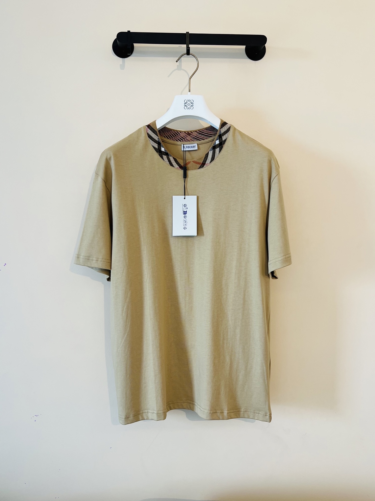 NO:480433,BBR plaided neck round neck short sleeves are available in black and khaki. Original, 000 purchase; lightweight flat cotton, casual style, integrated with brand webbing design, ribbed knit neckline, full set of auxiliary materials equipped # Pure cotton fabric material uses 15S fine cotton plain pattern, 230g; paired with 32S double yarn thread, 300g. Fine cotton fabric usually has good moisture absorption, breathability, wear resistance, and is also soft and smooth. Retro fine cotton fabric is thicker cotton fabric, finely processed and processed, has excellent texture and performance. It feels soft and comfortable to wear, and it fits the skin very well. # Integrated with brand webbing neckline design The plaid jacquard ribbed craft is one of the brand's iconic design elements, combining the classic Nova  Check plaid pattern and exquisite textile technology. Through mechanical jacquard loom, plaid patterns are directly weaved on the ribbed fabric; the pattern and the fabric are formed in one piece, with clear texture on the front and back sides, which are wear-resistant and not easy to fade, and have three-dimensional touch. The concave and convex texture of the ribbed tissue, and the jacquard ribs need to accurately control the color and tension of the plaid pattern to ensure the symmetry and coherence of the plaid pattern. # Double-needle thread sewn into garments. The round neck is cut straight, and the combination is slightly shoulder-falling line. The upper body is neatly decorated with a special motorcycle line. It is easier to deform after multiple washing. The fabric is made of pure cotton, high-density twill texture, and the embryo weaving is fine and has no elasticity to maintain the unique muscle and bone effect. Size m-3xL,,T-shirt,alexander wang19860909BBR格子领圆领短袖 发售色系黑色、卡其色 原,000购买；轻盈平织棉、休闲版型、融入品牌织带设计、罗纹针织领口、全套辅料配备 # 纯棉质面料材质 采用15S精棉平纹,230g；搭配 32S双纱拉架螺纹,300g.精棉面料通常具有较好的吸湿性、透气性、耐磨性,同时也比较柔软和光滑.复古精棉面料比较厚实的棉质面料,经过精细加工和处理,具有优良的质地和性能.手感柔软舒适,穿着起来非常贴合皮肤. # 融入品牌织带领口设计 格子提花罗纹工艺是其品牌标志性设计元素之一,结合了经典的Nova Check格子图案与精湛的纺织技术.通过机械提花织机,在罗纹织物上直接织出格纹的图案；图案与面料一体成型,正反面均有清晰纹理,耐磨、不易褪色,触感立体.罗纹组织的凹凸纹理,提花罗纹需精准控制纱线颜色与张力,确保格子图案的对称性与连贯性. # 双针走线缝制成衣 圆领直身裁剪、合体微落肩线,上身精神利落领口、袖口、底摆均以专机车明线,多次穿洗更加不易变形.面料纯棉材质,高密度斜纹肌理,胚布织法细密,无弹力保持特有筋骨效果. 尺码m-3xL,,T-shirt,alexander wang,Men's clothing