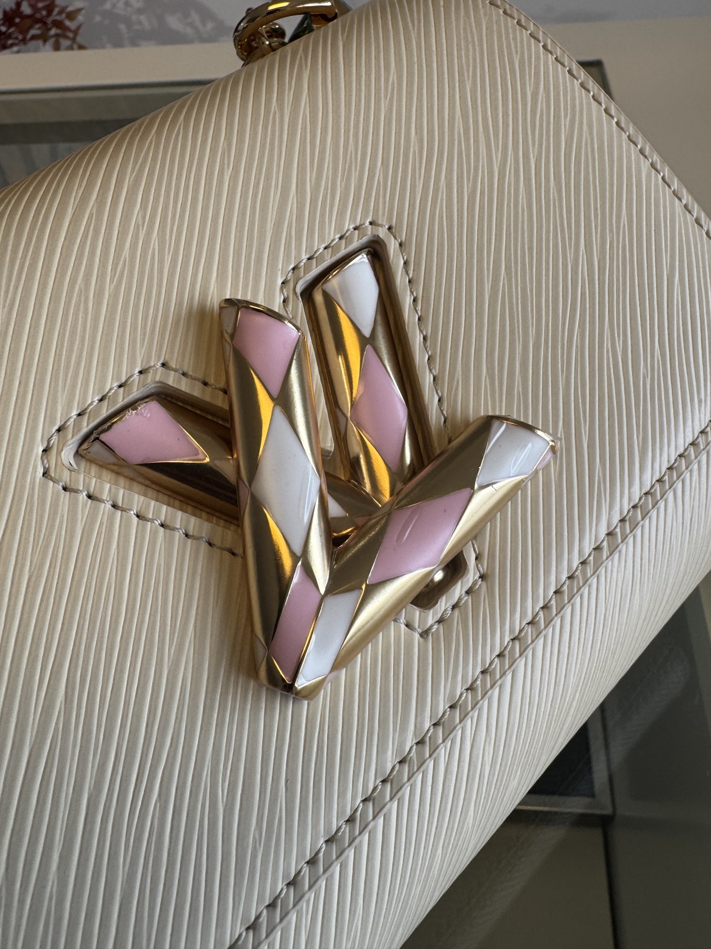 💰760TWIST 小号手袋
M12507米白
本款 Twist 小号手袋取材标志性 Epi 皮革，以绗缝元素和雅致珐琅重绎经典 LV Twist 扭锁，再借耀目滑链实现斜挎或肩背。齐整内部拥有多重口袋，配有可拆卸镜子和收纳日常所需的拉链隔层。
size:19x15x9cm