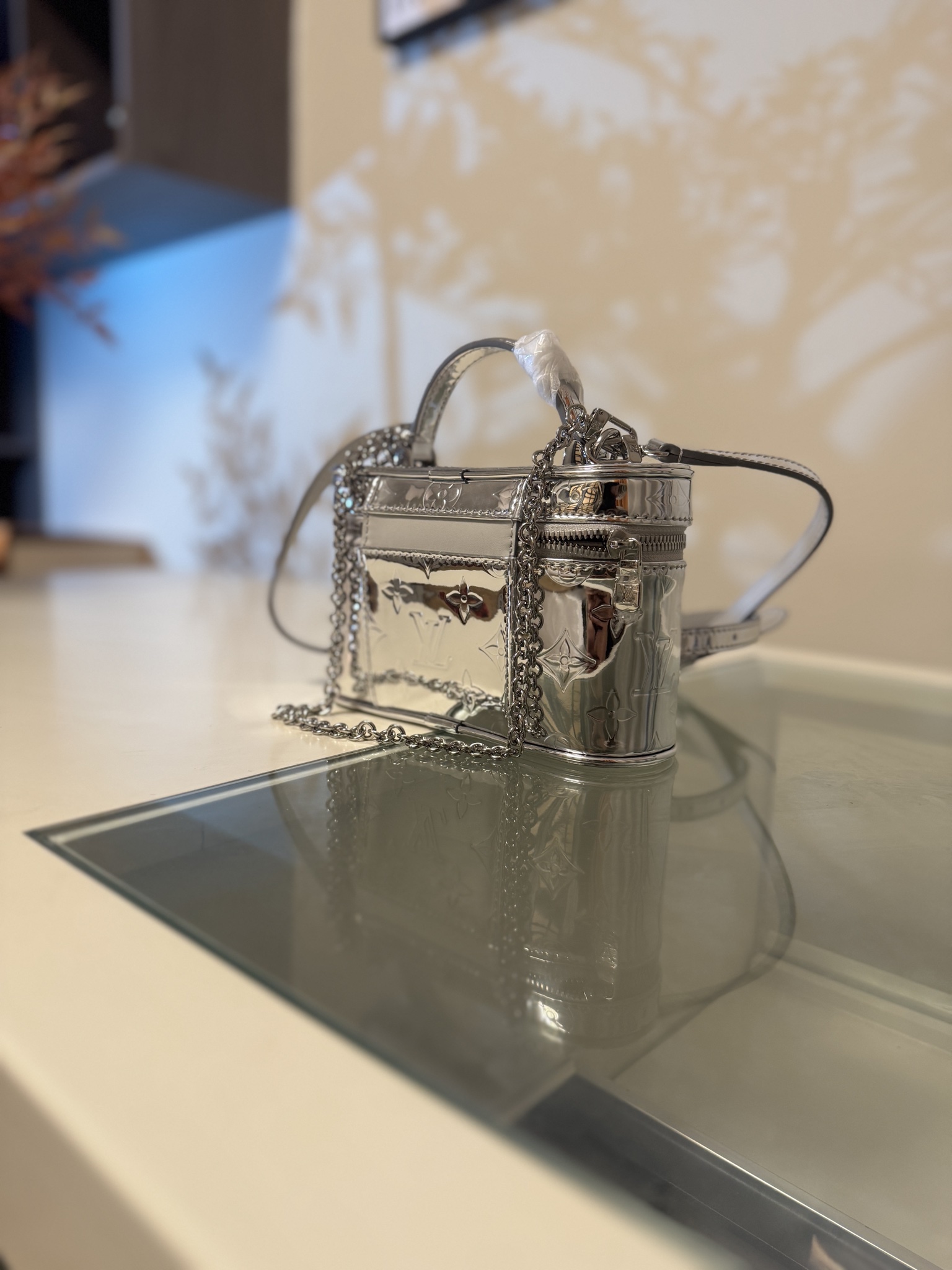 💰580VANITY CHAIN POUCH 手袋
M26097银色
本款 Vanity Chain Pouch 手袋出自 LV Ski 系列，向品牌传统化妆箱汲取灵感，以 Monogram Miroir 帆布诠释旅行精神。LV 字母铭纹挂锁、可拆卸肩带和链条彰显考究细节，恰宜构型可轻松容纳小型零钱包和太阳眼镜等日常所需。尺寸：11.5 x 6.5 x 19cm