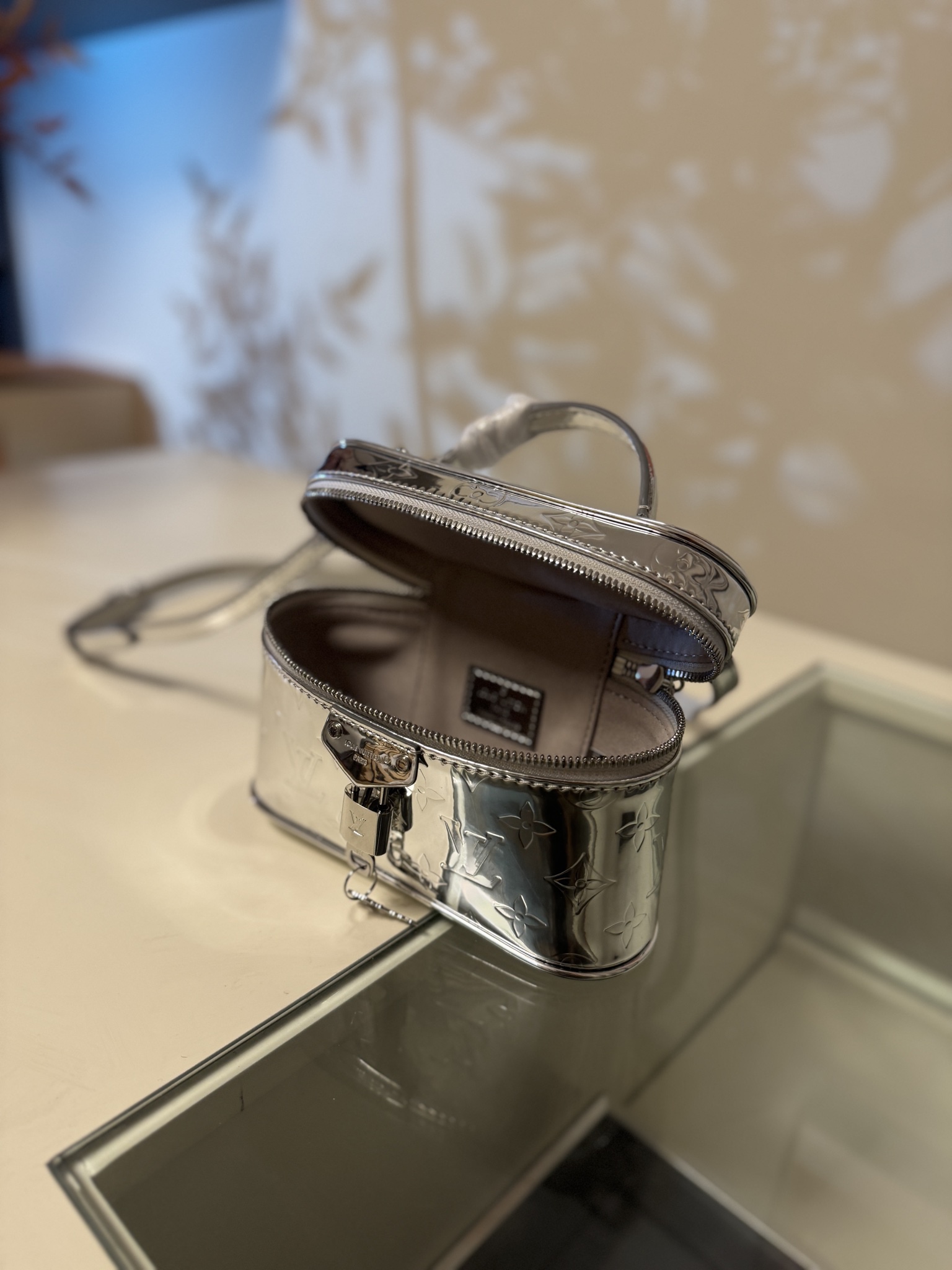 💰580VANITY CHAIN POUCH 手袋
M26097银色
本款 Vanity Chain Pouch 手袋出自 LV Ski 系列，向品牌传统化妆箱汲取灵感，以 Monogram Miroir 帆布诠释旅行精神。LV 字母铭纹挂锁、可拆卸肩带和链条彰显考究细节，恰宜构型可轻松容纳小型零钱包和太阳眼镜等日常所需。尺寸：11.5 x 6.5 x 19cm