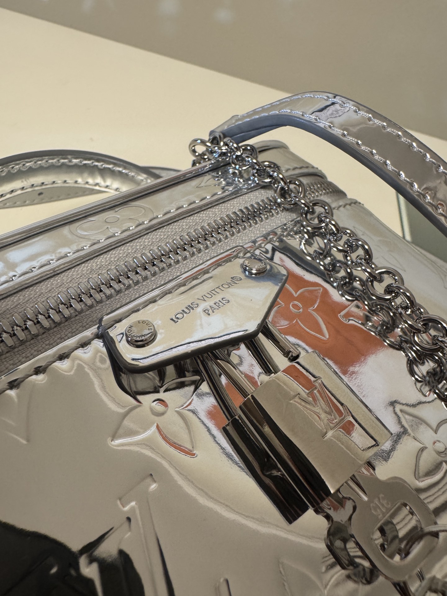 💰580VANITY CHAIN POUCH 手袋
M26097银色
本款 Vanity Chain Pouch 手袋出自 LV Ski 系列，向品牌传统化妆箱汲取灵感，以 Monogram Miroir 帆布诠释旅行精神。LV 字母铭纹挂锁、可拆卸肩带和链条彰显考究细节，恰宜构型可轻松容纳小型零钱包和太阳眼镜等日常所需。尺寸：11.5 x 6.5 x 19cm