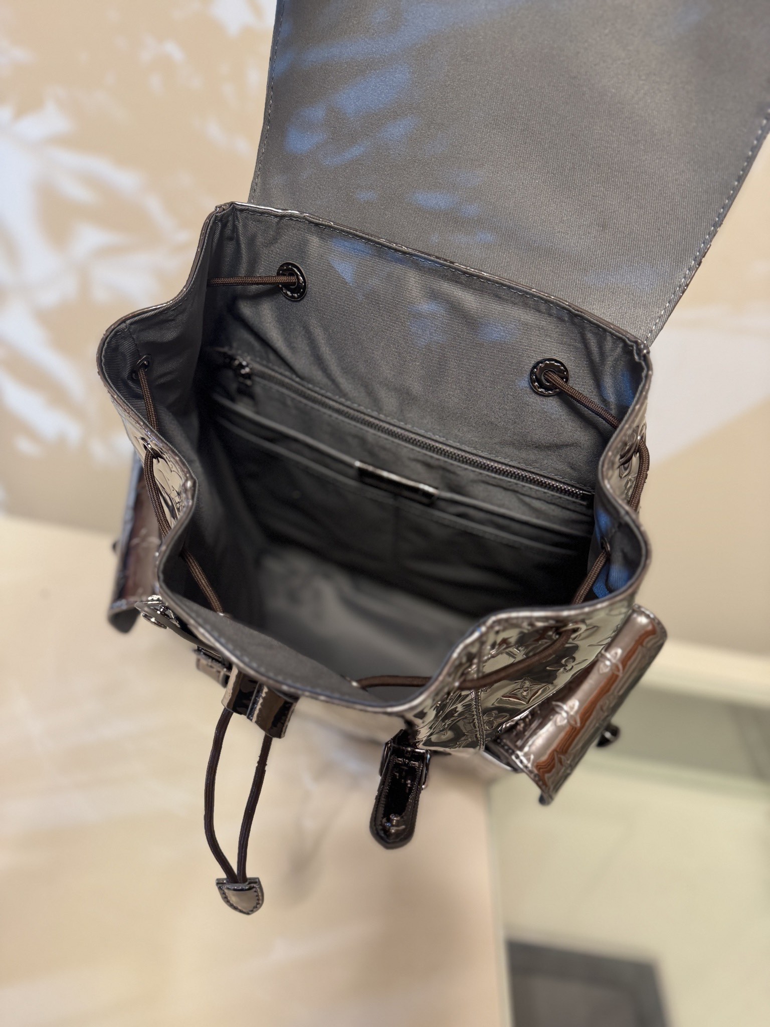 💰880CHRISTOPHER 中号双肩包
M27051 枪色
本款 Christopher 中号双肩包为 Monogram Miroir 涂层帆布渲染莹泽色调，营造粗粝装甲观感。光滑饰边与 Monogram 压纹构筑视觉反差。宽敞侧袋与双按扣及抽绳成就出行良伴。尺寸：38 x 44 x 12.5cm