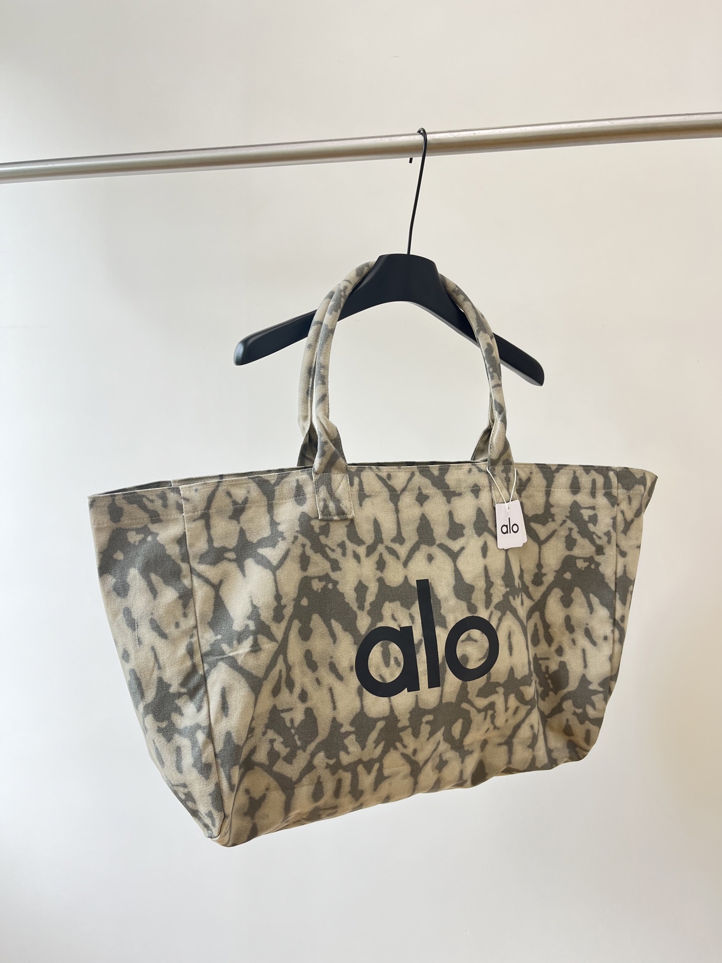 NO:944366,Introduction to the ALO tie-dye canvas tote bag 1. The printed color is retro gray tone tie-dye pattern, the low saturated khaki background is matched with gray camouflage texture, lazy and relaxed, American sports style, the color matching is versatile. 2. The brand logo bag has an eye-catching black capital ALO letter logo printed on the front, which is highly recognizable, non-market version, top version. 3.  Extra large open tote version, wide shoulder and double straps, no hard support, soft canvas material, light weight. Thickened washed canvas, wear-resistant and durable, the fabric is soft and tough, slightly waterproof, and the interior is not easily soaked by daily splashing water. Capacity and practicality Extra large space, sufficient capacity, can accommodate yoga clothes, sports shoes, water bottles, computers, parasols, skin care products, etc., simple separation, convenient access to items. Applicable scenarios  The fitness yoga brand specializes in yoga sports, and packs sports suits, yoga mats, and toiletries; packs books and laptops for commuting to and from school, which is light and light; it can be packed with large capacity for shopping, shopping, shopping, and picnics. Dimensions: length 68cm, width 16cm, height 38cm, sneakers, totes,19860909ALO扎染帆布托特包介绍 1. 印花配色复古灰调扎染斑纹,低饱和卡其底色搭配灰迷彩纹理,慵懒松弛,美式运动风,配色百搭不挑穿搭. 2. 品牌标识包身正面印有醒目黑色大写alo字母logo,辨识度高,非市场版本,顶级版. 3. 版型超大敞口托特版型,宽肩手提双带,无硬支撑,软帆布材质,自重轻便. 加厚水洗帆布,耐磨耐造,布料柔软有韧性,轻微防水,日常溅水不易浸湿内部. 容量与实用性 超大空间,容量充足,可容纳瑜伽服、运动鞋、水杯、电脑、遮阳伞、护肤品等,分隔简单,拿取物品方便. 适用场景 健身瑜伽品牌主打瑜伽运动,装运动套装、瑜伽垫、洗护用品； 通勤上学装书本、笔记本电脑,轻便减负； 逛街出游短途出门、超市采购、野餐,大容量超能装. 尺寸:长68cm宽16cm高38cm,,sneakers,totes,,Women's clothing