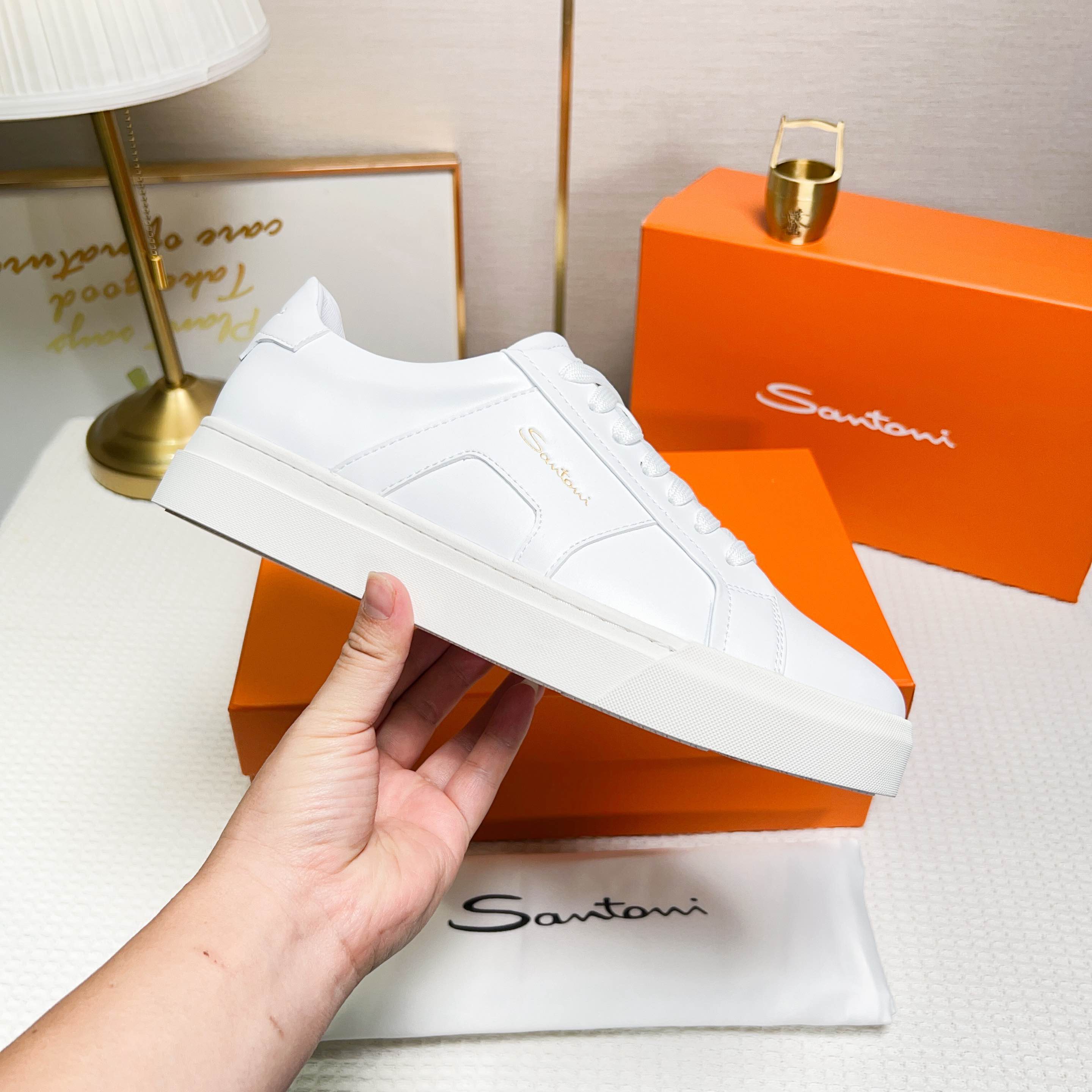 NO:272315,Santoni (Santoni) This is a men's low-top sports shoe with unique design and distinctive style, designed for men. The material and color are made of leather, white, and it looks clean and neat. Design features The tongue and heel are decorated with leather brand logo to highlight the quality. The side design is inspired by double buckles to add a sense of fashion. The wide version and round toe design are comfortable to wear. The lace-like tightness is convenient for adjusting elasticity. The rubber cup sole is wear-resistant and has strong grip. The sole is molded with Santoni letters, reflecting the brand characteristics. Made in Italy, sizes 38-44 (customized by 45),19860909Santoni(圣东尼) 这是一款设计独特、风格鲜明的男士低帮运动 鞋,专为男士设计. 材质与颜色采用皮革材质,颜色为白色,显 得干净利落. 设计特色 鞋舌和鞋跟处饰有皮革品牌标识,彰显品 质. 侧面设计灵感来源于双扣,增添时尚感. 宽版型和圆头设计,穿着舒适. 鞋带式紧固,方便调节松紧. 橡胶杯型鞋底,耐磨且抓地力强. 鞋底模压有Santoni字母,体现品牌特色. 产地意大利制造 38-44码（45定做）,,Men's shoes