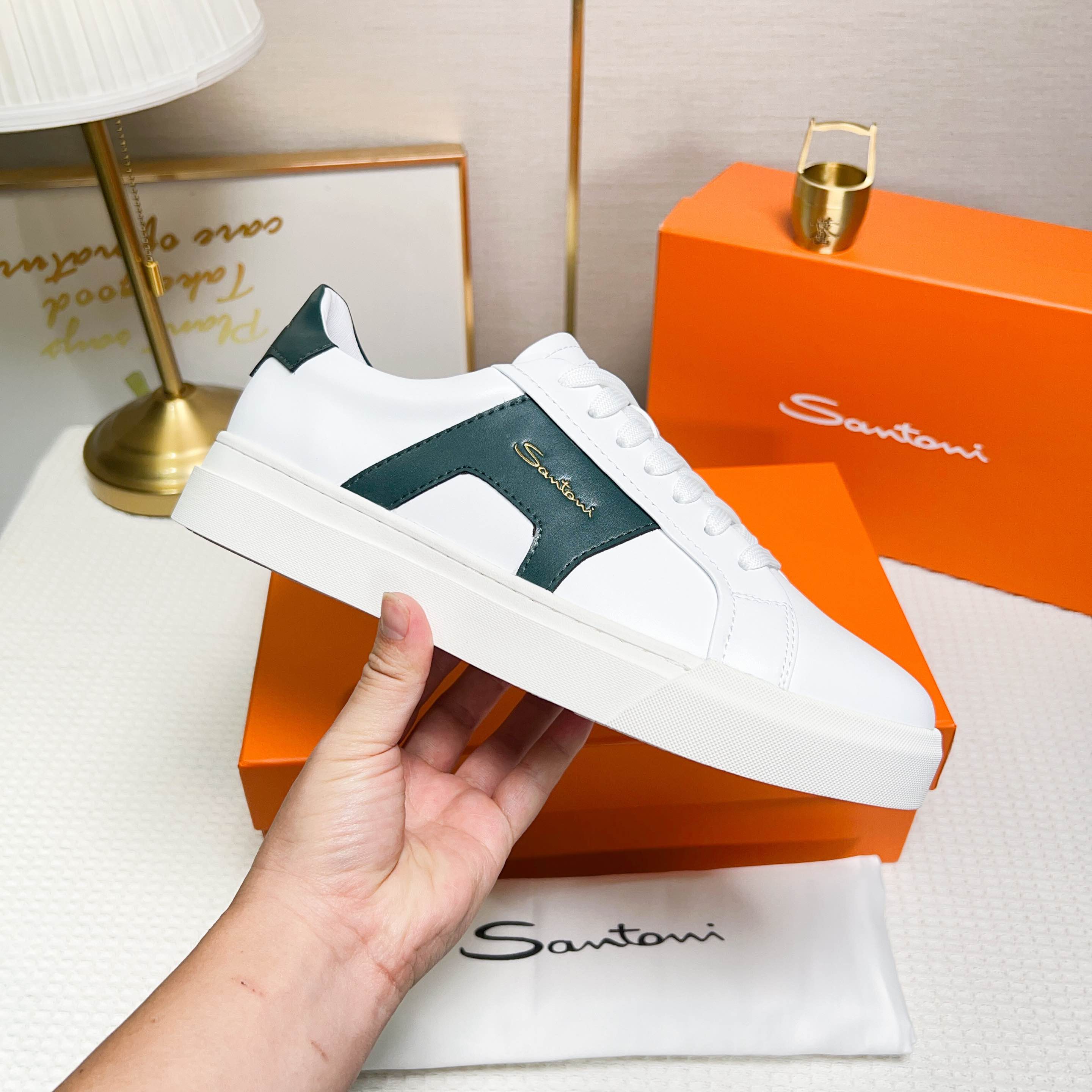 NO:272327,Santoni is a men's low-top sneaker made of leather, in white and orange, with exquisite and distinctive design details. Material and color The shoe is made of leather, the main color is white and green, with bright and fashionable color. Design details The tongue and heel are decorated with leather brand logo, and the side design is designed with double buckles and inspiration for the shoe, which adds to the design sense of the shoe. The style and the shoes are designed with wide style and round toe, and are comfortable to wear. The lace-up fixing method is used to facilitate adjustment of elasticity. The sole is constructed with rubber cup-shaped sole, which is wear-resistant and has good grip. The sole is molded with Santoni letters to highlight the brand's characteristics. Origin: The shoe is produced in Italy. This sneaker combines fashion and comfort, suitable for daily wear or special occasions.  38-44 codes (45 custom made), sneakers19860909Santoni(圣东尼) 这是一款男士低帮运动鞋,采用皮革材质,颜色 为白色和橙色,设计细节精致且富有特色. 材质与颜色该鞋采用皮革制作,主体颜色为 白色和绿色,配色鲜明且时尚. 设计细节鞋舌和鞋跟处饰有皮革品牌标识, 侧边设计有双扣环灵感的细节,增加了鞋子的设 计感. 版型与穿着鞋子为宽版型和圆头设计,穿着 舒适.采用系带式固定方式,方便调节松紧. 底部构造鞋底为橡胶杯型底,耐磨且具有良 好的抓地力.鞋底模印有Santoni字母,彰显品牌 特色. 产地该鞋产于意大利 这款运动鞋融合了时尚与舒适,适合日常穿着或 特殊场合搭配. 38-44码（45定做）,,sneakers,Men's shoes