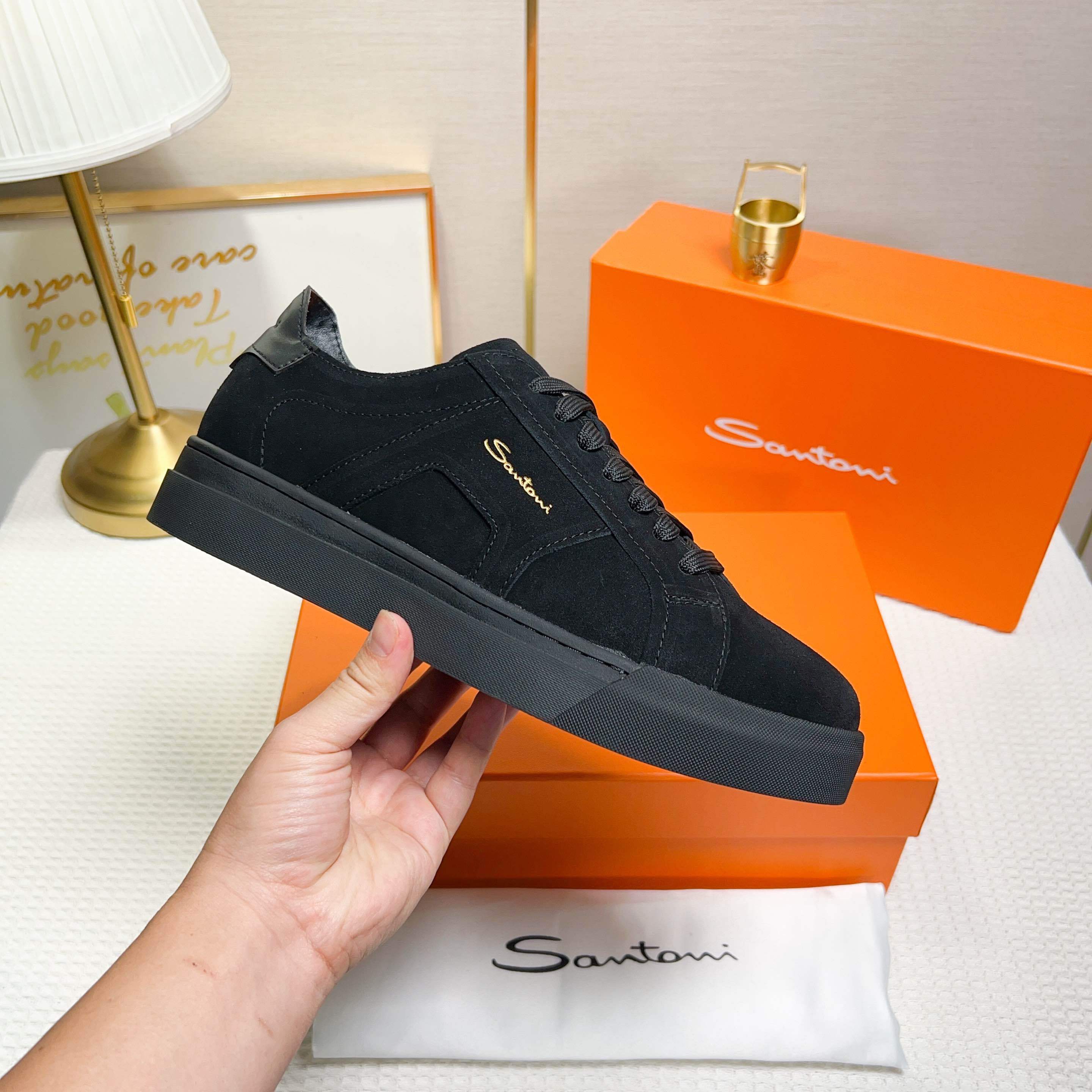 NO:272337,Santoni is a men's low-top sneaker made in Italy. The material and construction are made of fur, unlined and deconstructed, giving a simple style. The color and details are black, with leather brand logo on the tongue and heel, and leather details inspired by double buckles on the sides to add a sense of fashion. The wear is lace-up design, which is convenient for adjusting tightness and ensuring a comfortable fit. The sole features rubber cup sole, which is wear-resistant and has strong grip, with Santoni letters printed on the bottom, highlighting the brand identity. This sneaker combines fashion and practicality, suitable for daily casual wear. Size 38-44 (customized for 45),, sneakers19860909Santoni(圣东尼) 这是一款男士低帮运动鞋,由意大利制造. 材质与构造采用翻毛皮制作,未加内衬且解 构设计,呈现简约风格. 颜色与细节鞋身为黑色,鞋舌和鞋跟处饰有 皮革品牌标识,侧边则以双扣环为灵感设计的皮 革细节,增添时尚感. 穿着方式采用系带设计,方便调整松紧度, 确保舒适贴合. 鞋底特色橡胶杯型鞋底,耐磨且抓地力强, 底部印有Santoni字母,彰显品牌身份. 这款运动鞋融合了时尚与实用,适合日常休闲穿 着. 38-44码（45定做）,,sneakers,Men's shoes