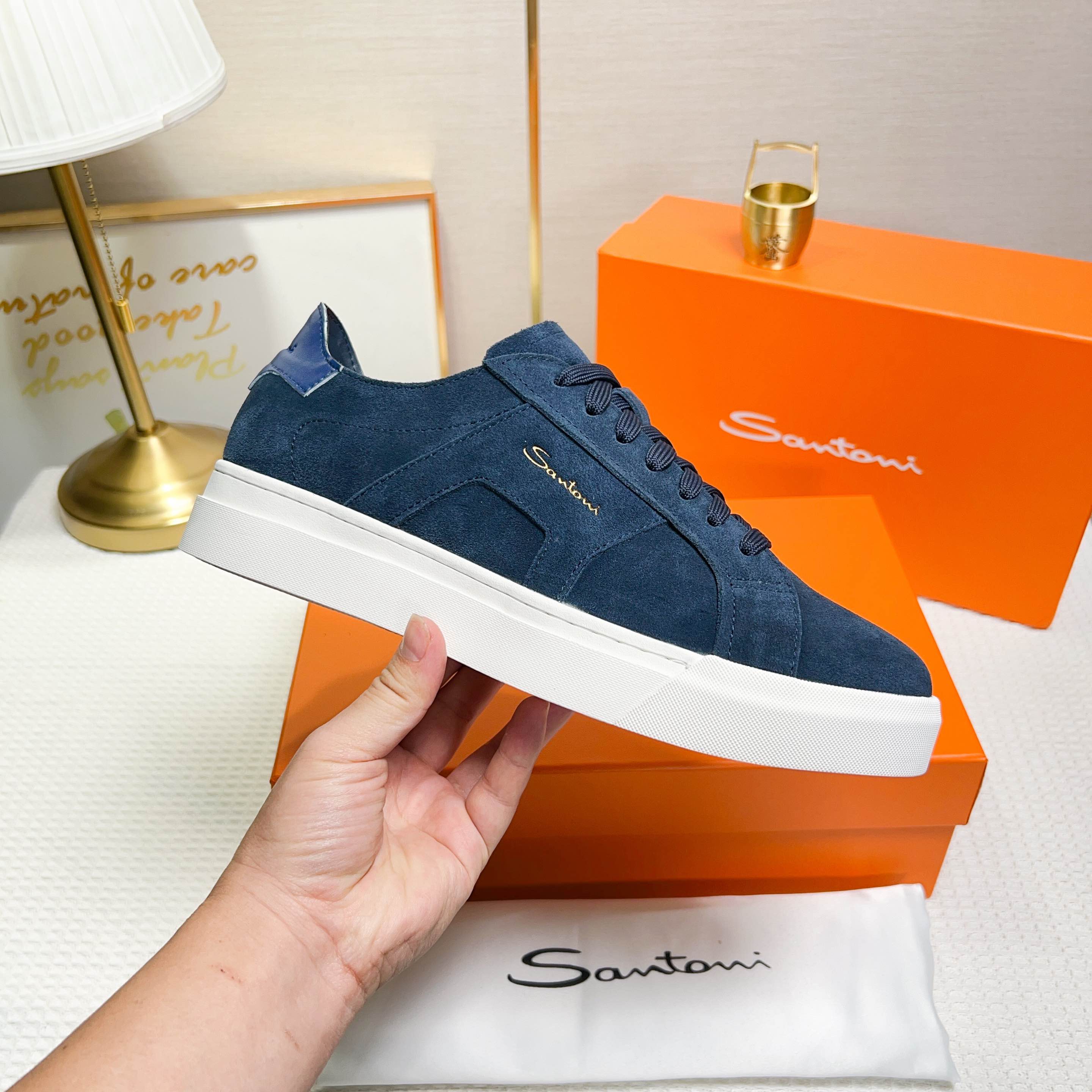 NO:272334,Santoni is a men's low-top sneaker made in Italy. The material and structure are made of fur, unlined and deconstructed, giving a simple style. The color and details are blue, with leather brand logo on the tongue and heel, and leather details inspired by double buckles on the sides to add a sense of fashion. The wear is lace-up design, which is convenient for adjusting tightness and ensuring a comfortable fit. The sole features rubber cup sole, which is wear-resistant and has strong grip, and the Santoni letters are printed on the bottom, highlighting the brand identity. This sneaker combines fashion and practicality, suitable for daily casual wear. Size 38-44 (customized for 45),, sneakers19860909Santoni(圣东尼) 这是一款男士低帮运动鞋,由意大利制造. 材质与构造采用翻毛皮制作,未加内衬且解 构设计,呈现简约风格. 颜色与细节鞋身为兰色,鞋舌和鞋跟处饰有 皮革品牌标识,侧边则以双扣环为灵感设计的皮 革细节,增添时尚感. 穿着方式采用系带设计,方便调整松紧度, 确保舒适贴合. 鞋底特色橡胶杯型鞋底,耐磨且抓地力强, 底部印有Santoni字母,彰显品牌身份. 这款运动鞋融合了时尚与实用,适合日常休闲穿 着. 38-44码（45定做）,,sneakers,Men's shoes