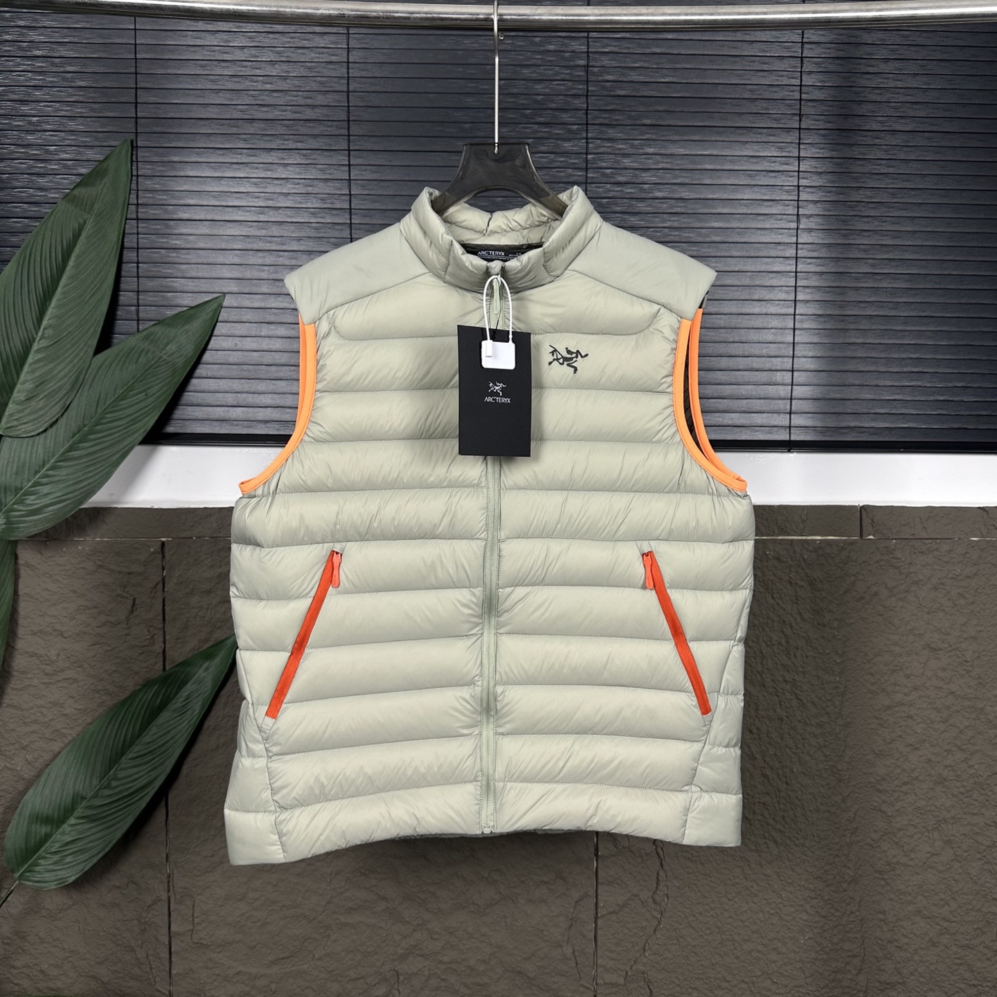 【顶级独家实拍】 ARCTERYX Cerium vest 纯色休闲拉链立领羽绒马甲 款号:DJ08341 Cerium Vest 排骨马甲 整件马甲采用超轻量的面料和填充,可以轻松卷缩成自身的一个口袋中,形成一个非常小的收纳包. 收纳后体积仅比一个可乐罐稍大,重量极轻(约200-250克,取决于尺码),几乎不占任何背包空间,非常适合作为应急保暖层随身携带 极其轻便,收纳性强:无可匹敌的便携性. 多功能性:适用于从高强度户外到城市生活的多种场景. 出色的透气性:复合面料设计确保运动时不会过热. 防潮保暖:鹅绒填充应对多变天气更可靠. 剪裁合身:外观简洁利落 颜色: 黑色 破晓蓝 岩灰绿