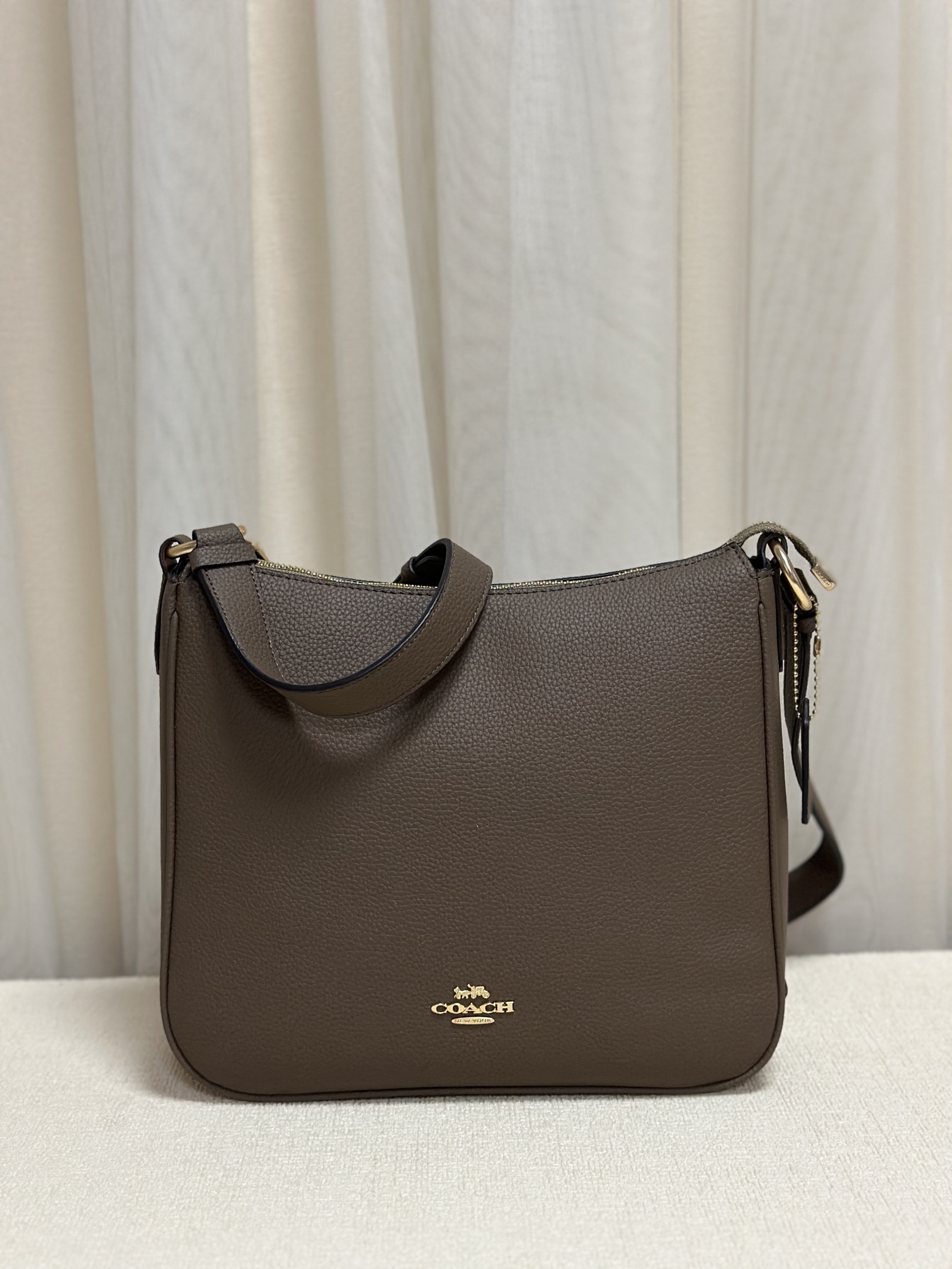 New Coach C1648 Ellie crossbody bag featuring the iconic Coach C monogram coated canvas and leather trim. Adjustable shoulder strap, multiple interior pockets, top zip closure, exterior zip pocket, fabric lining. Classic and stylish, dimensions 26*24*6, available in gray-brown. image 1