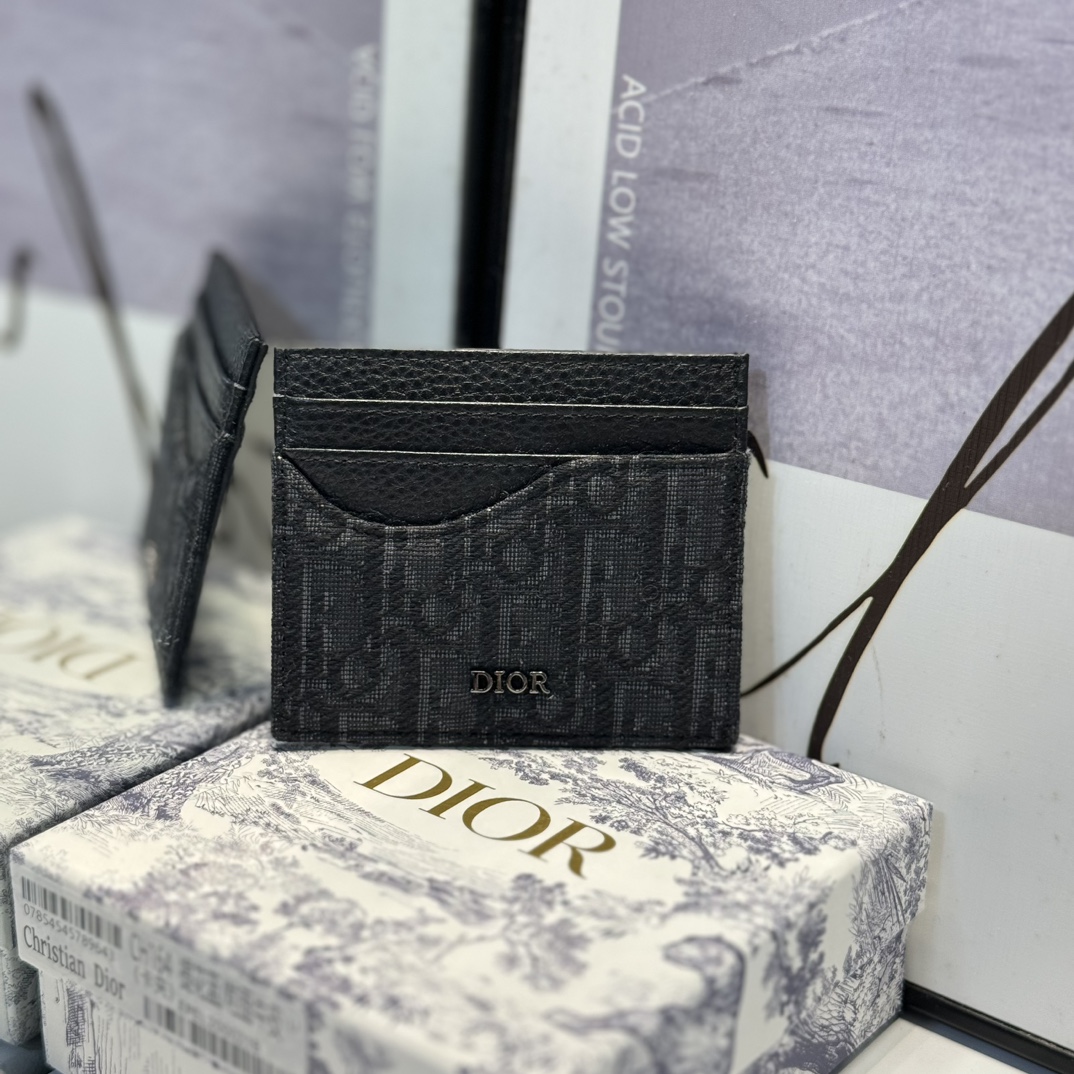 NO:672688,CH164 The Saddle Card Holder is an elegant accessory that showcases Dior's masterful leather marquetry. Crafted from black grained calfskin and beige and black Oblique print fabrics, it highlights the Saddle collection's classic silhouette. It has three card slots on each side and one in the center of the top to store a variety of personal items. Elegant style, with the Dior signature on the front, it can be easily slipped into any pocket. Dimensions 10 x 8 cm (length x height)  Can store bank cards 6 card slots Central card slot Receipt slip pocket Metal-coated brass Dior logo on the front Dior embossed logo on the inside Dust bag included, Dior wallet, dior, wallets, cowhide19860909CH164这款马鞍卡夹是一款高雅的配饰,彰显 Dior 精湛的皮革细工镶嵌工艺.采用黑色粒面牛皮革和米色与黑色 Oblique 印花面料精心制作,突显马鞍系列的经典廓形,两侧各设有三个卡槽,顶部中央设有一个卡槽,可收纳各种个人物品.款式优雅,正面饰以 Dior 标志,可轻松放入各式口袋中. 尺寸10 x 8 厘米（长 x 高） 可收纳银行卡 6 个卡槽 中央卡槽 票据插袋 正面金属覆层黄铜 Dior 标志 内侧饰有 Dior 压花标志 内含防尘袋,Dior钱包,dior,wallets,cowhide,欧美剧