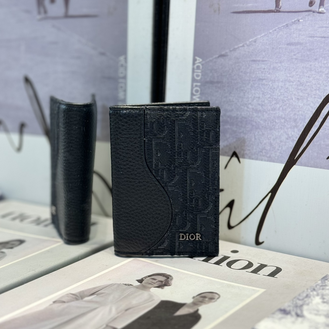 NO:672681,CH169 The Saddle Vertical Bi-fold Card Holder is an elegant accessory that showcases Dior's savoir-faire. Crafted from black inlaid grained calfskin with beige and black Oblique print fabrics, it highlights the classic saddle silhouette. There are three card slots on each side and two receipt pockets. Elegant style, with the Dior signature on the front, it can be easily slipped into any pocket. Dimensions 8.2 x 11.2 cm (L x H) Can store bank cards  Smooth cow leather interior 6 card slots 2 receipt pockets Brass metal-clad Dior logo on front Dior embossed logo on inside Dust bag included, Dior wallet, dior, wallets, cowhide19860909CH169这款马鞍竖版双折卡夹是一款高雅的配饰,彰显 Dior 的精湛工艺.采用黑色细工镶嵌粒面牛皮革搭配米色和黑色 Oblique 印花面料精心制作,突显经典的马鞍廓形.两侧各设有三个卡槽,另外设有两个票据插袋.款式优雅,正面饰以 Dior 标志,可轻松放入各式口袋中. 尺寸8.2 x 11.2 厘米（长 x 高） 可收纳银行卡 内部采用光滑牛皮革 6 个卡槽 2 个票据插袋 正面金属覆层黄铜 Dior 标志 内侧饰有 Dior 压花标志 内含防尘袋,Dior钱包,dior,wallets,cowhide,欧美剧