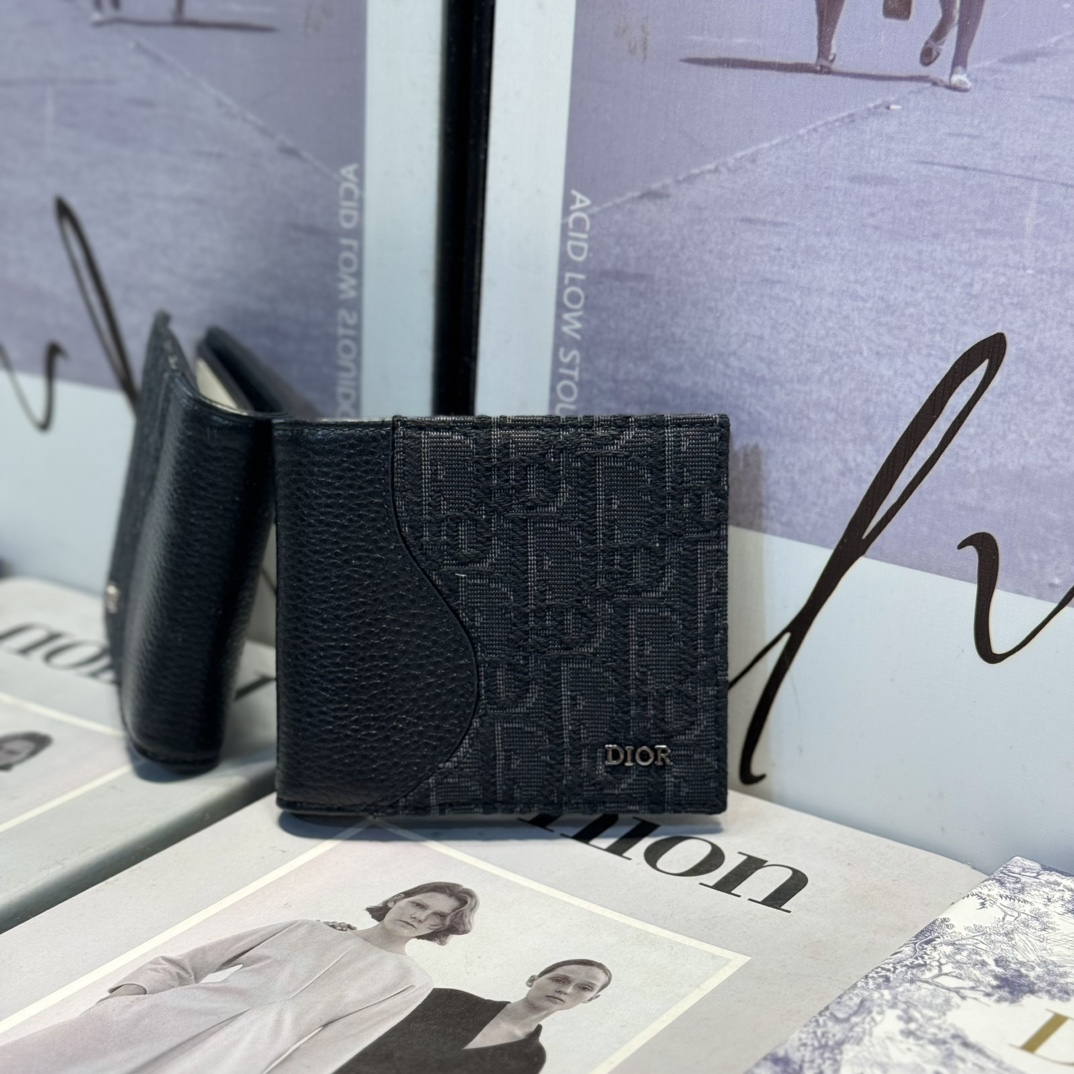 NO:672391,BH076 The Saddle Bifold Card Holder is an elegant accessory that showcases Dior's savoir-faire. Crafted from black inlaid grained calfskin with beige and black Oblique print fabrics, it highlights the classic saddle silhouette and features a double cash compartment, two receipt pockets and eight card slots. The bi-fold design, finished with a metal-clad brass Dior signature on the front, fits easily into any pocket or handbag.. Dimensions 11.5 x 9.5  cm (Length19860909BH076 这款马鞍双折卡夹是一款高雅的配饰,彰显 Dior 的精湛工艺.采用黑色细工镶嵌粒面牛皮革搭配米色和黑色 Oblique 印花面料精心制作,突显经典的马鞍廓形,内部设有一个双层现金隔层、两个票据插袋和八个卡槽.双折设计,正面饰以金属覆层黄铜 Dior 标志,可轻松放入各式口袋或手袋中.. 尺寸11.5 x 9.5 厘米（长 x 高）. 可收纳银行卡 内部采用光滑牛皮革 8 个卡槽 2 个票据插袋 双层现金隔层 正面金属覆层黄铜 Dior 标志 内侧饰有 Dior 压花标志 内含防尘袋,Dior钱包,dior,wallets,cowhide,欧美剧
