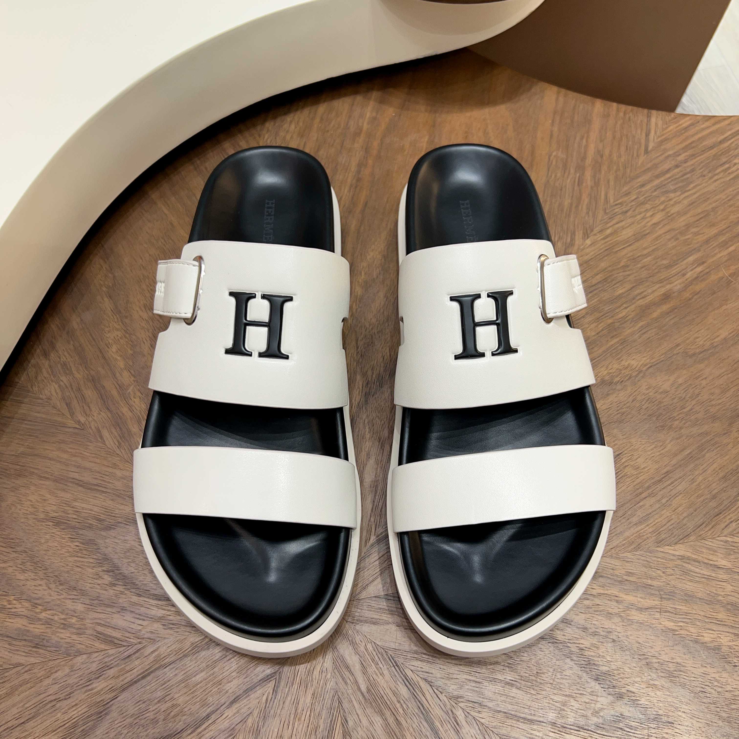 NO:779010,[HERMES] Men's size 39-44 (customized at 38.45.46) 2026. Hermès slippers series high-end brand, made of original materials, high-quality leather upper + non-slip wear-resistant outsole Design highlights double belt structure, metal H decorative buckle, adjustable buckle design, breathable and comfortable, light luxury and versatile Colors classic black, pure white, high-end gray, caramel brown, hermes, hermes, slippers19860909【HERMES】 男款size 39-44（38.45.46定做） 2026.爱马仕拖鞋系列高端品牌 ,原版材料制作, 材质优质皮革鞋面+防滑耐磨大底 设计亮点双条皮带结构,金属H装饰扣,可调节搭扣设计,透气舒适,轻奢百搭 颜色经典黑、纯净白、高级灰、焦糖棕,,hermes,hermes,slippers,Men's shoes