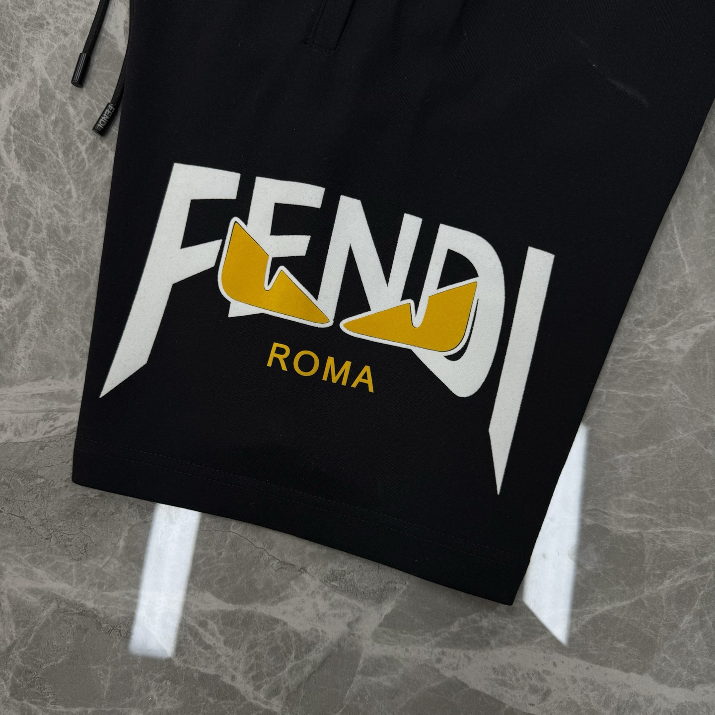 
        FEND*I芬迪25s新款五分短裤🩳两侧无缝工艺.侧腿品牌图形字母搭配小怪兽烫画设计.
