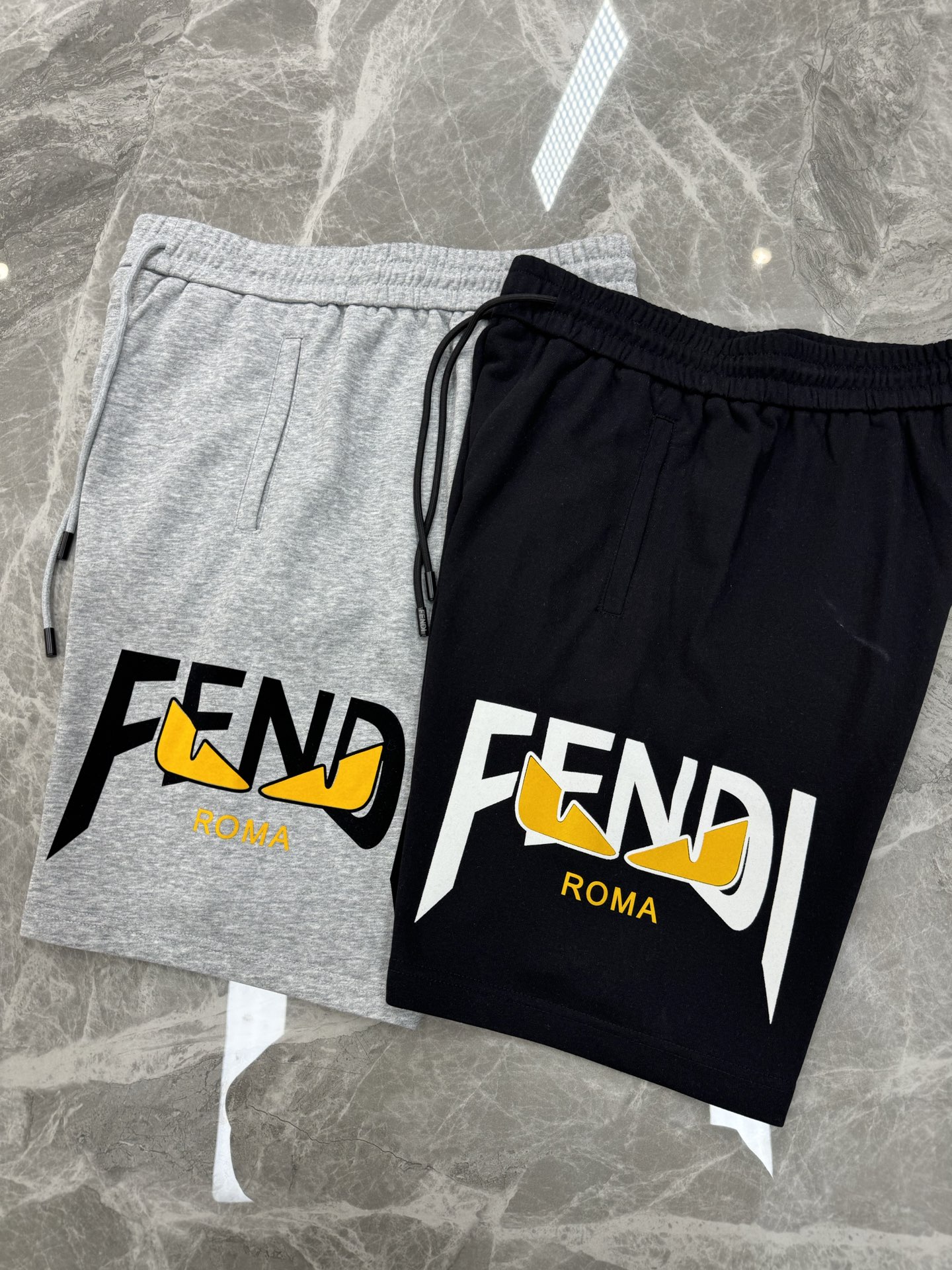 
        FEND*I芬迪25s新款五分短裤🩳两侧无缝工艺.侧腿品牌图形字母搭配小怪兽烫画设计.