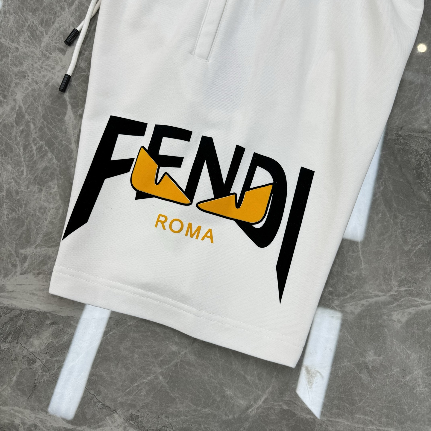 
        FEND*I芬迪25s新款五分短裤🩳两侧无缝工艺.侧腿品牌图形字母搭配小怪兽烫画设计.