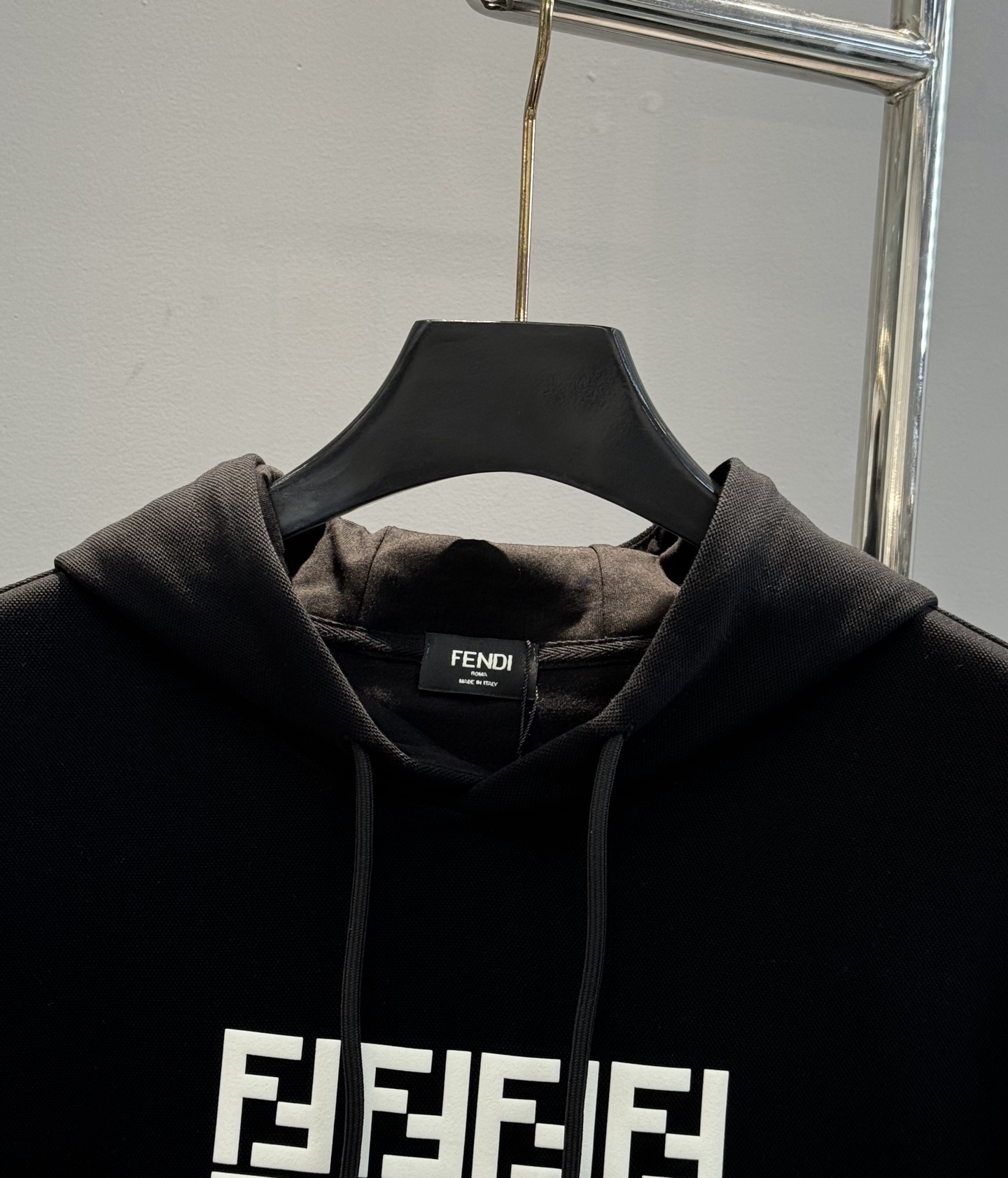 FENDI芬迪2025新款小怪兽图案T连帽卫衣.“FEND”品牌标志部分字母FF规矩图形被设计成一对黑色